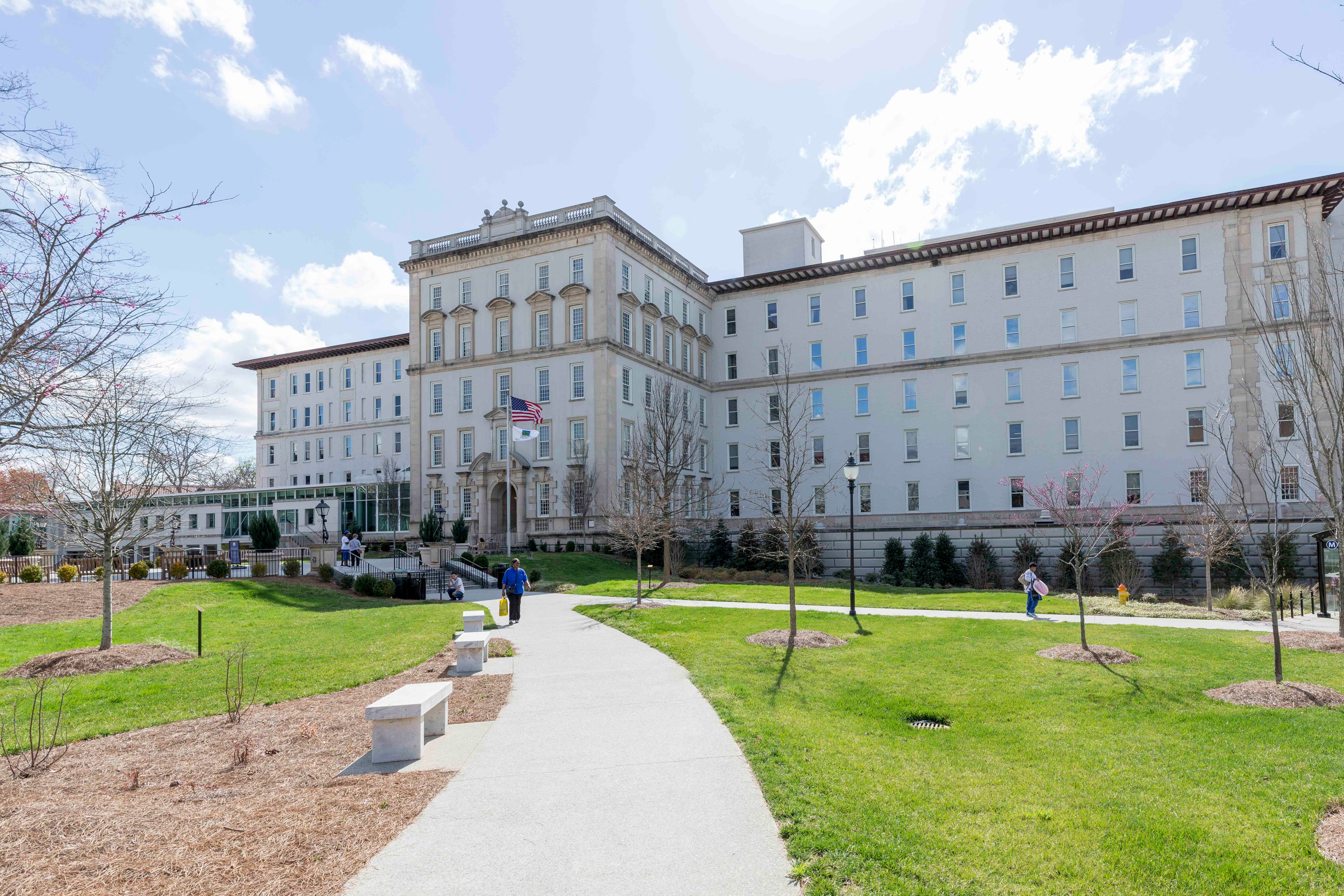 A large building with green grass in the foreground and a blue sky in the background.