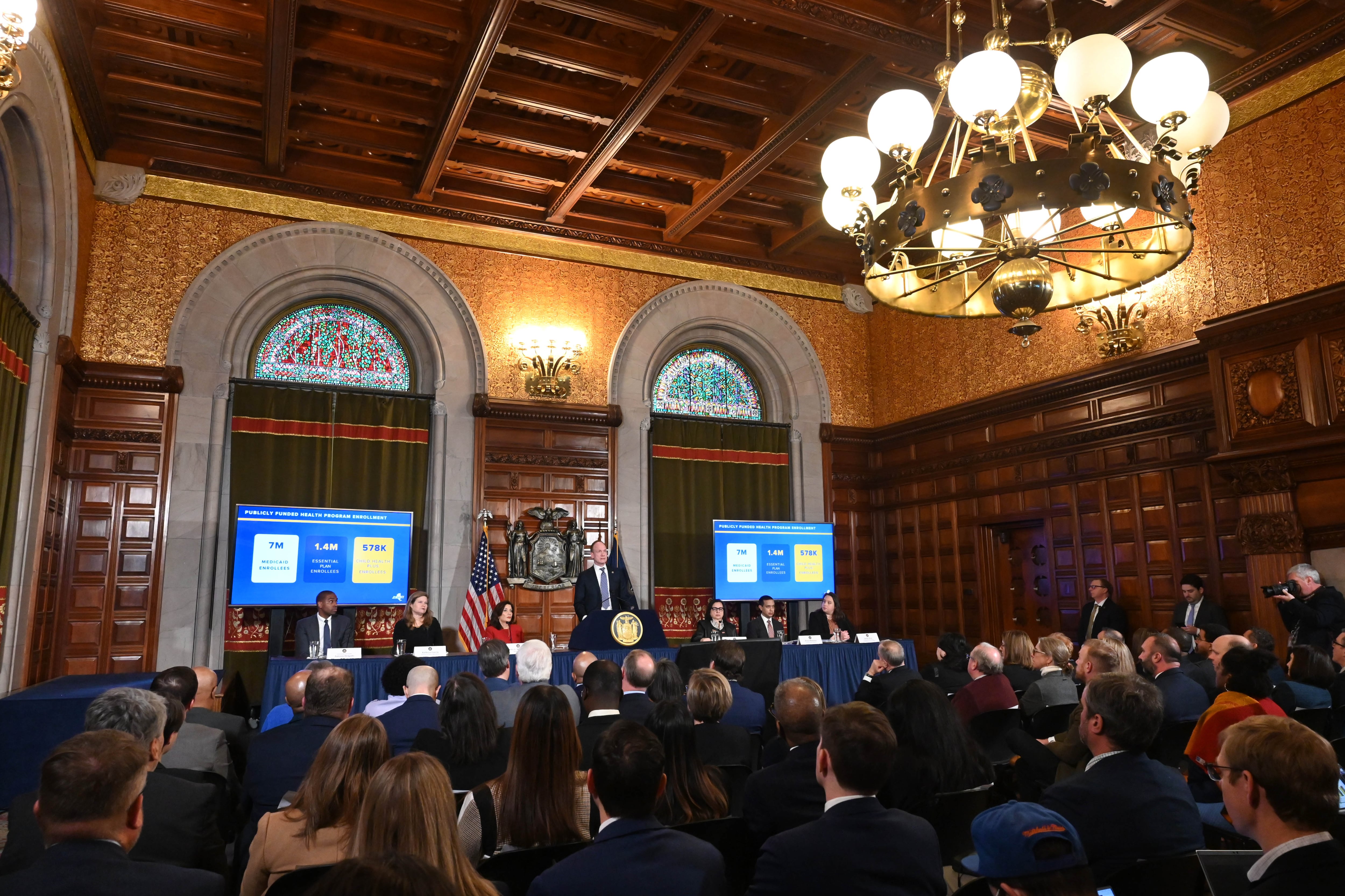 New York budget director Blake Washington stands at a podium before a room full of people.