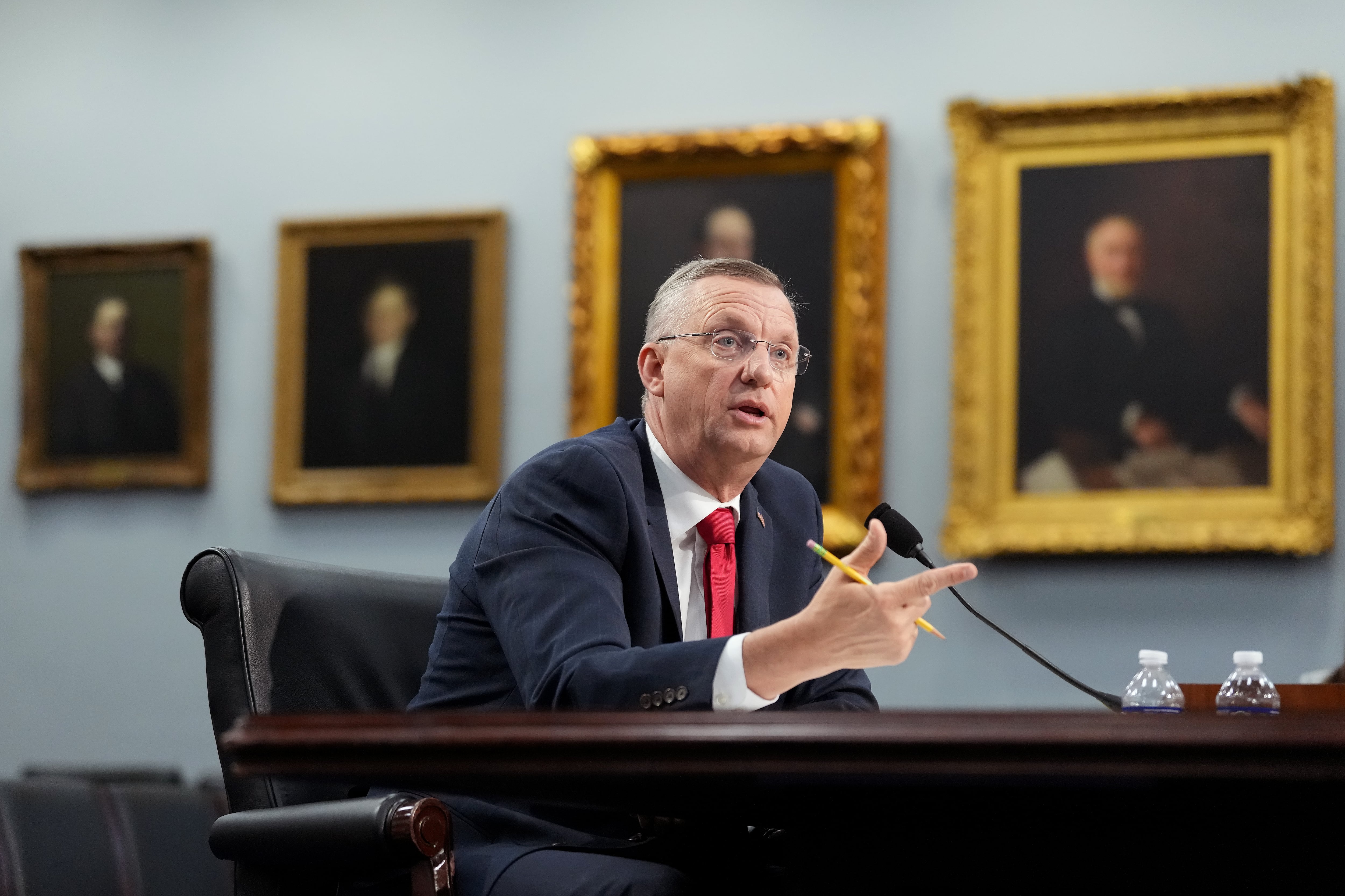 Doug Collins is seated in front of a microphone to testify in Congress.