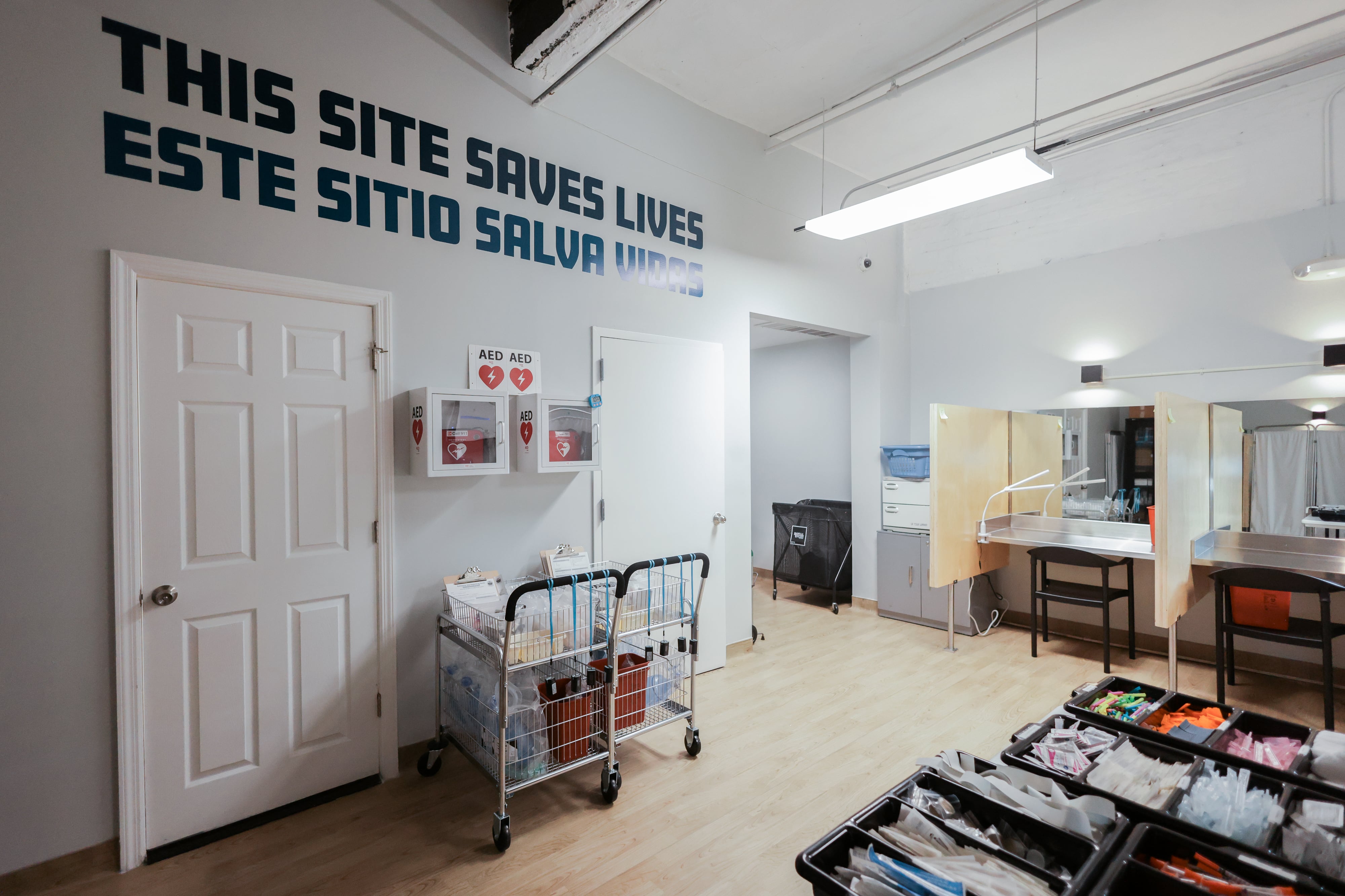 An empty overdose prevention center has this painted slogan on the wall: This site saves lives.