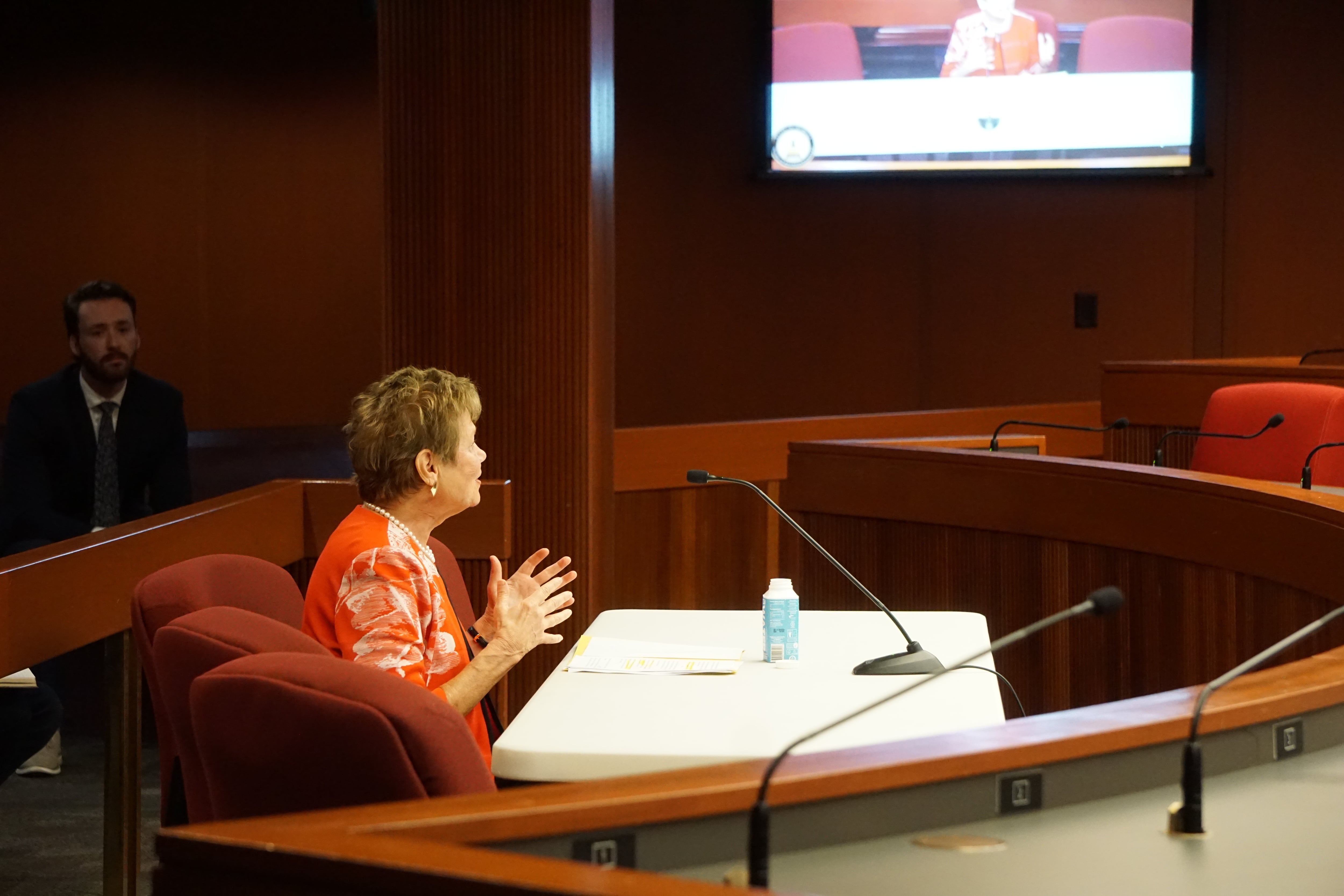 Georgia Public Health Commissioner Kathleen Toomey sits at a table with a microphone.