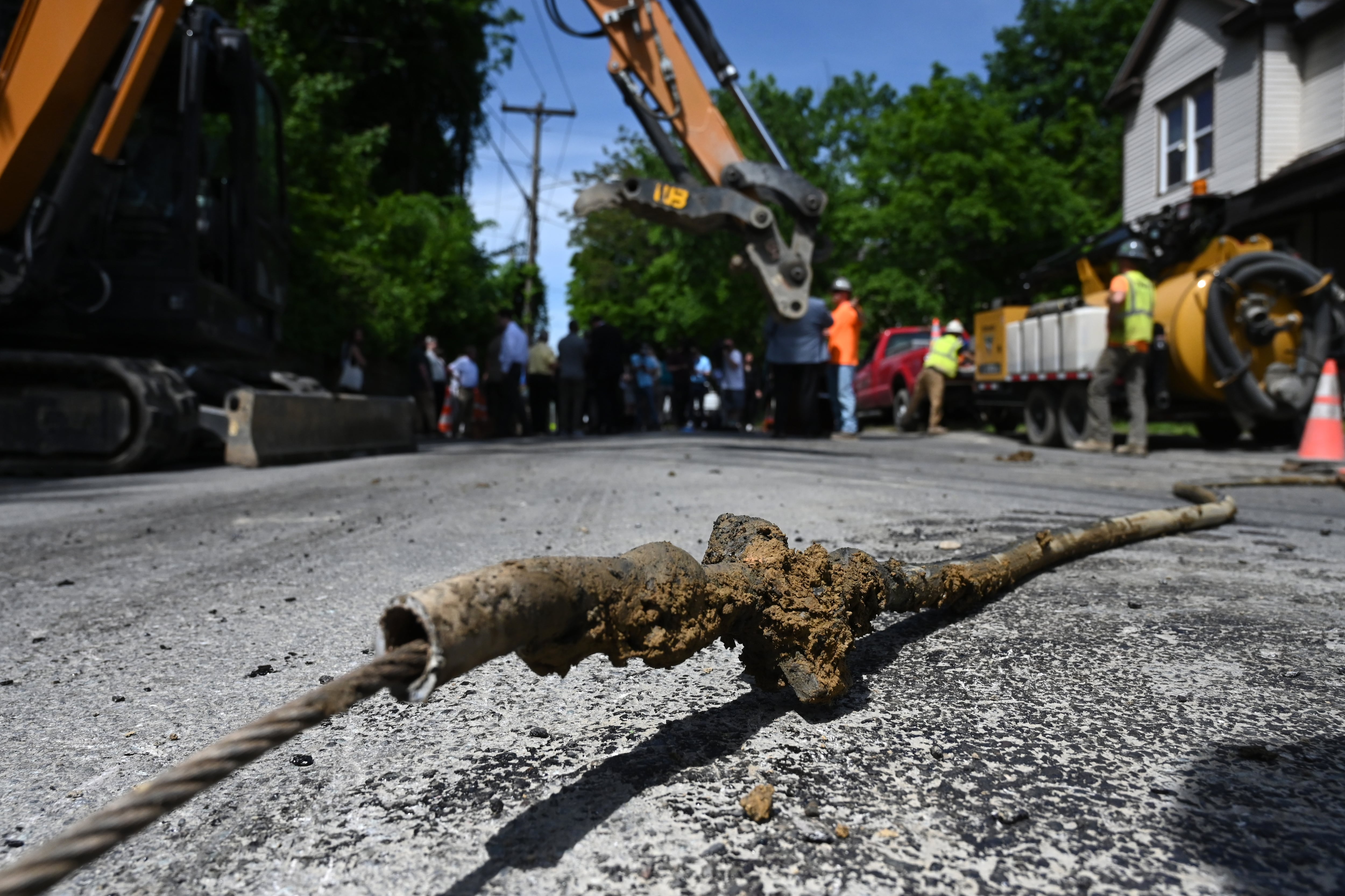 A section of lead pipe that supplied drinking water to a home lies on the street.