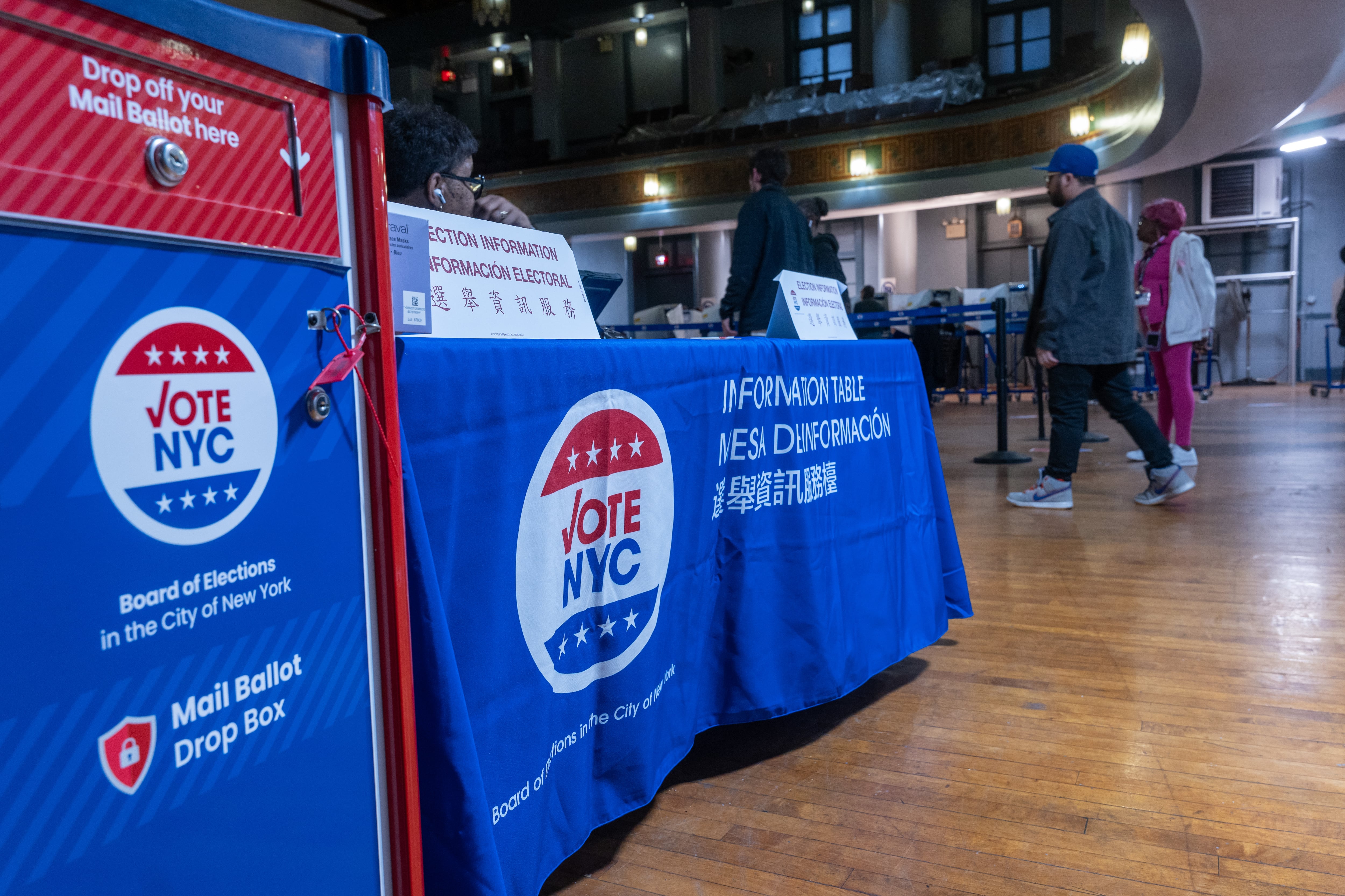 A mail ballot drop-off box stands next to a table at an early voting site.