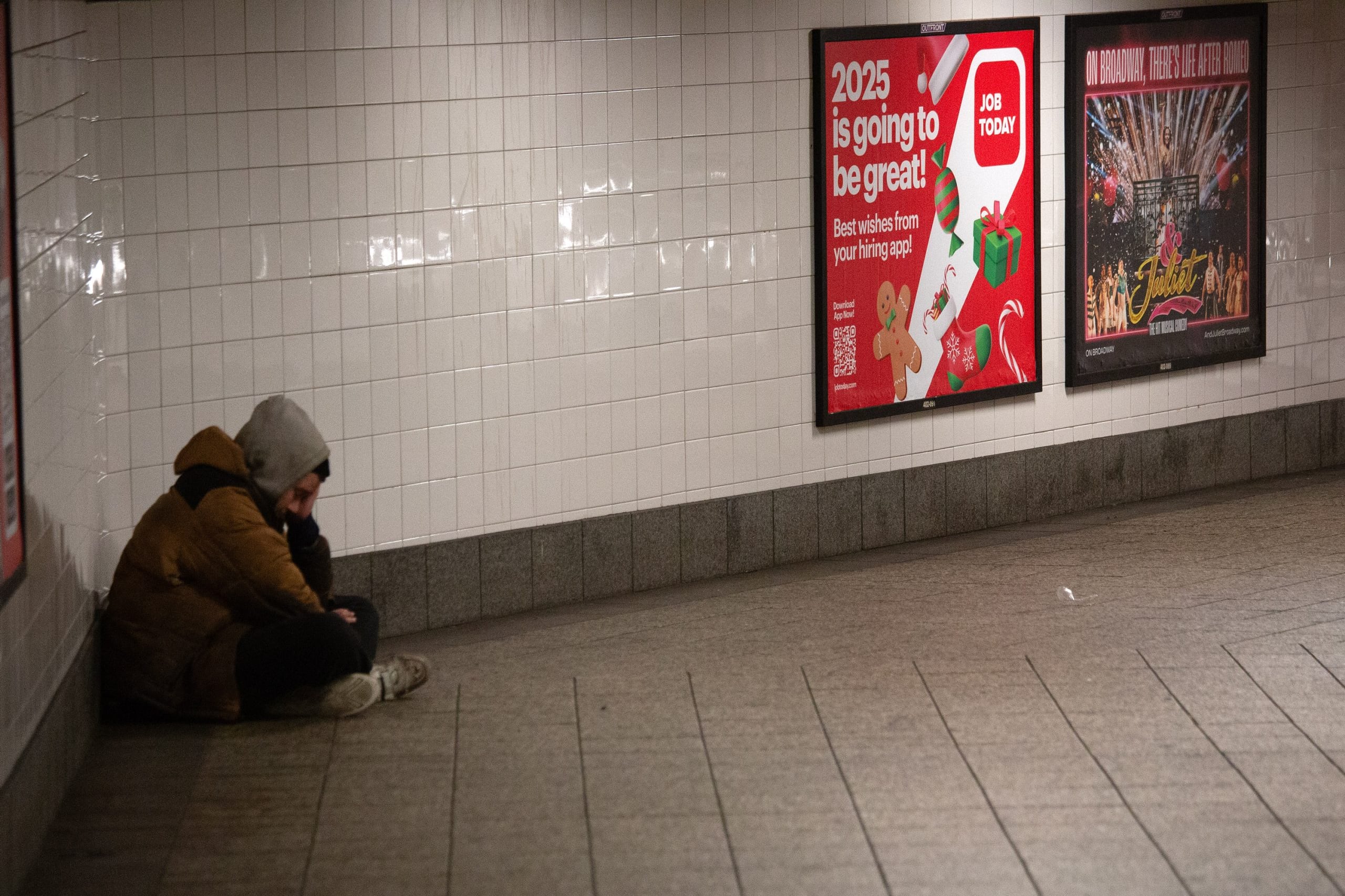 A man is shown sitting in a walkway of Grand Central Terminal in New York City.