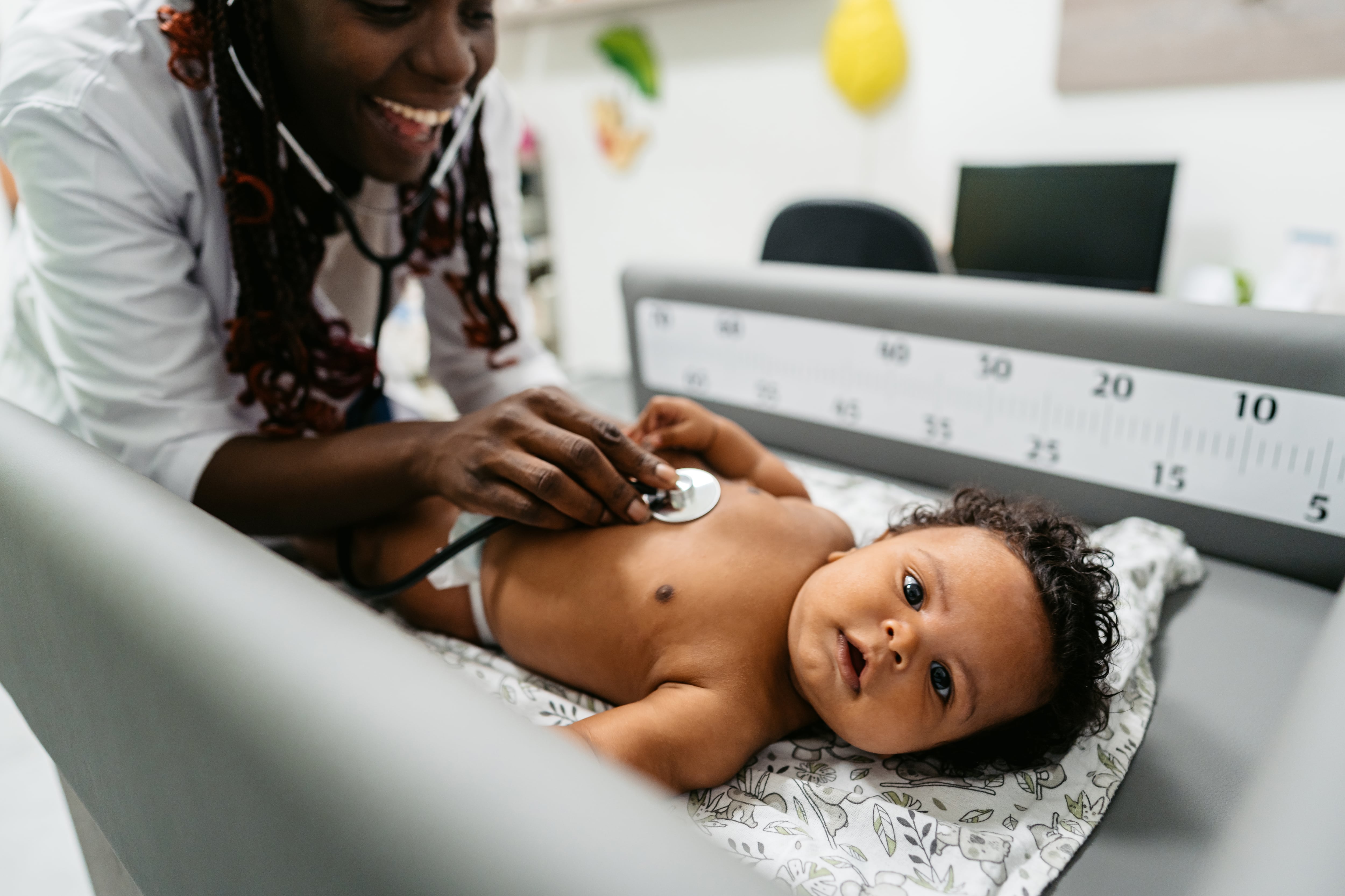 Close-up of a female pediatrician examining a baby in the hospital.