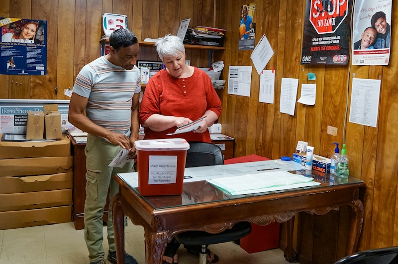 A man and woman work inside an HIV testing clinic.