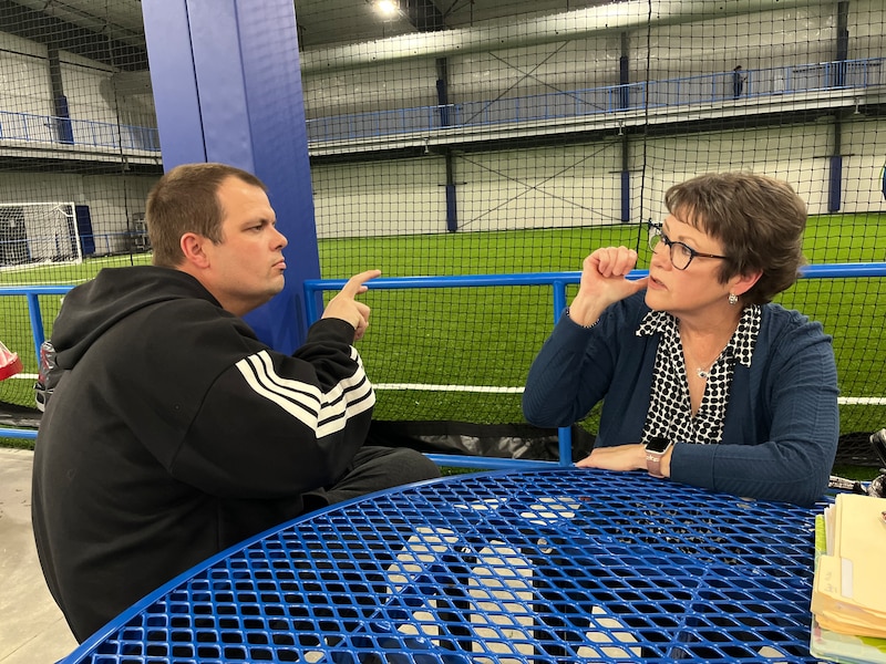 Sam Walker and his mother converse in sign language.