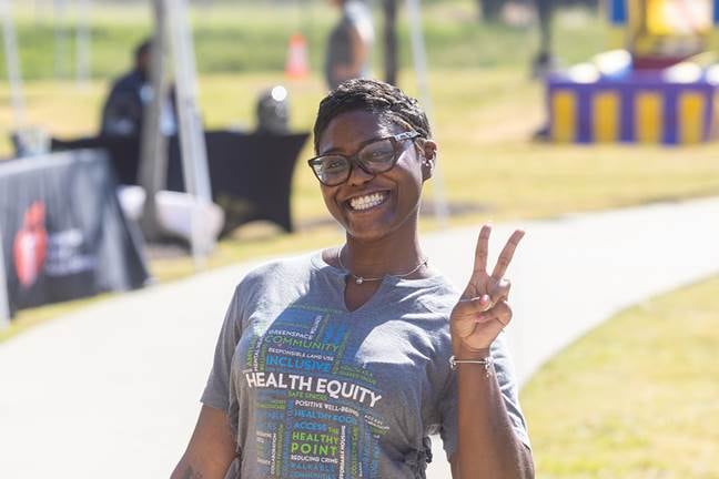 Zakiyah Morris holds her fingers in a peace sign in an outdoor setting.