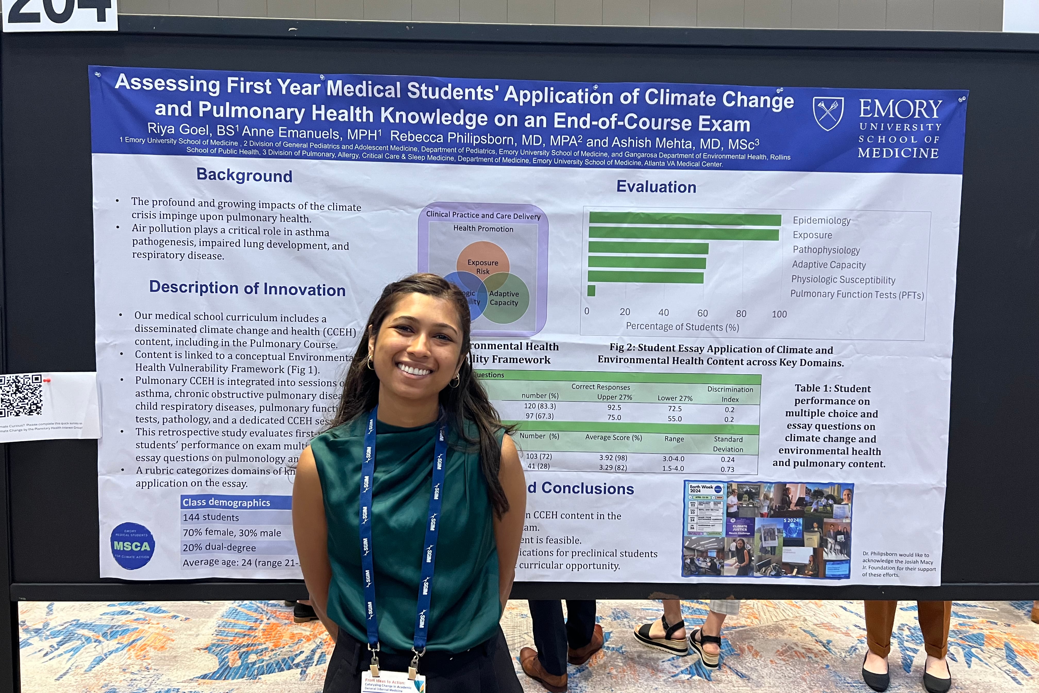 A woman in a green top stands in front of a scientific conference poster.