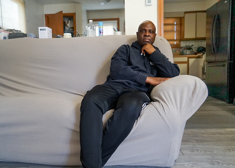 Kwesi Ablordeppey sits on a sofa.