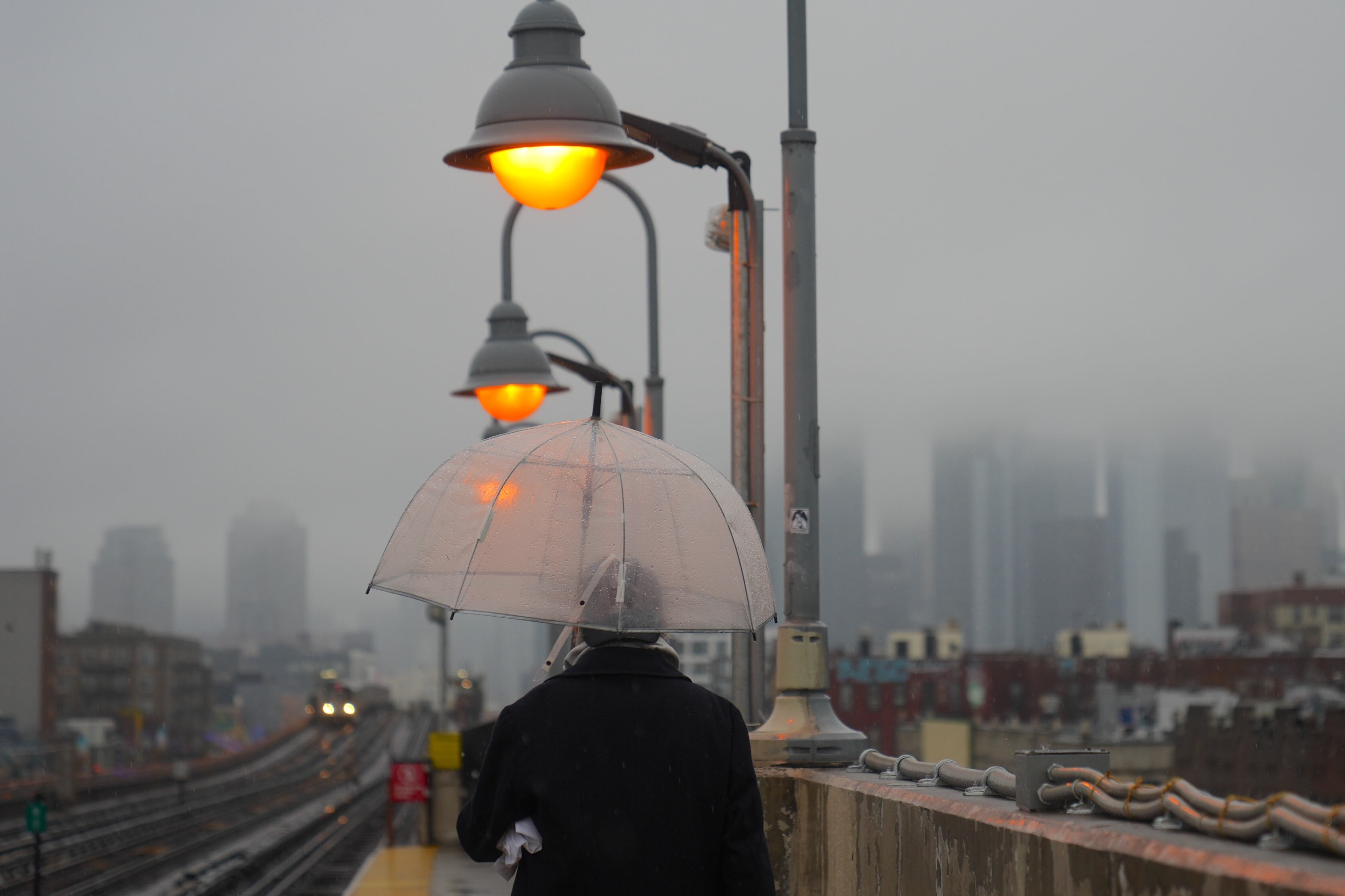 A person walks with an umbrella on a rainy day in New York City.