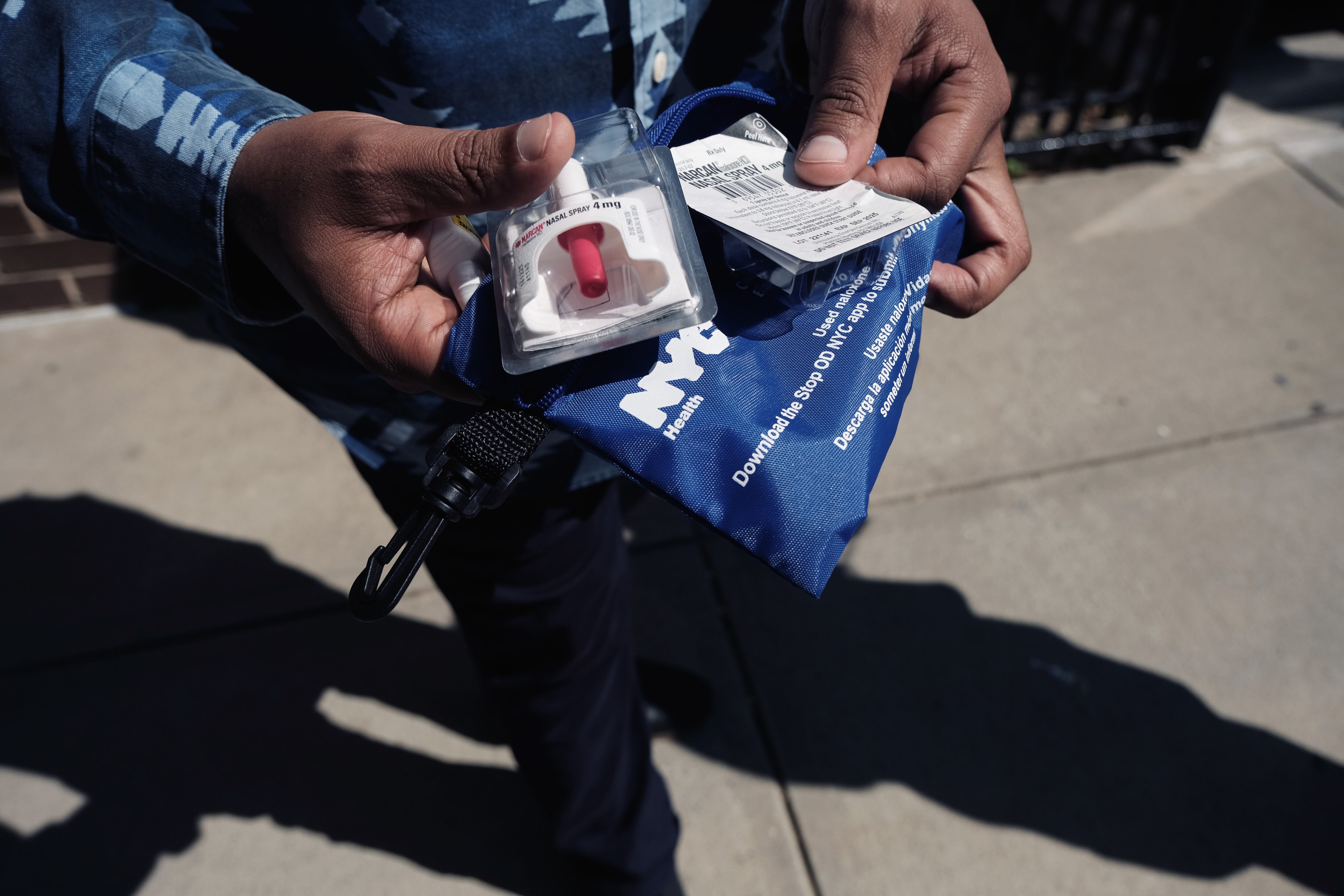 A worker holds a naloxone overdose kit.