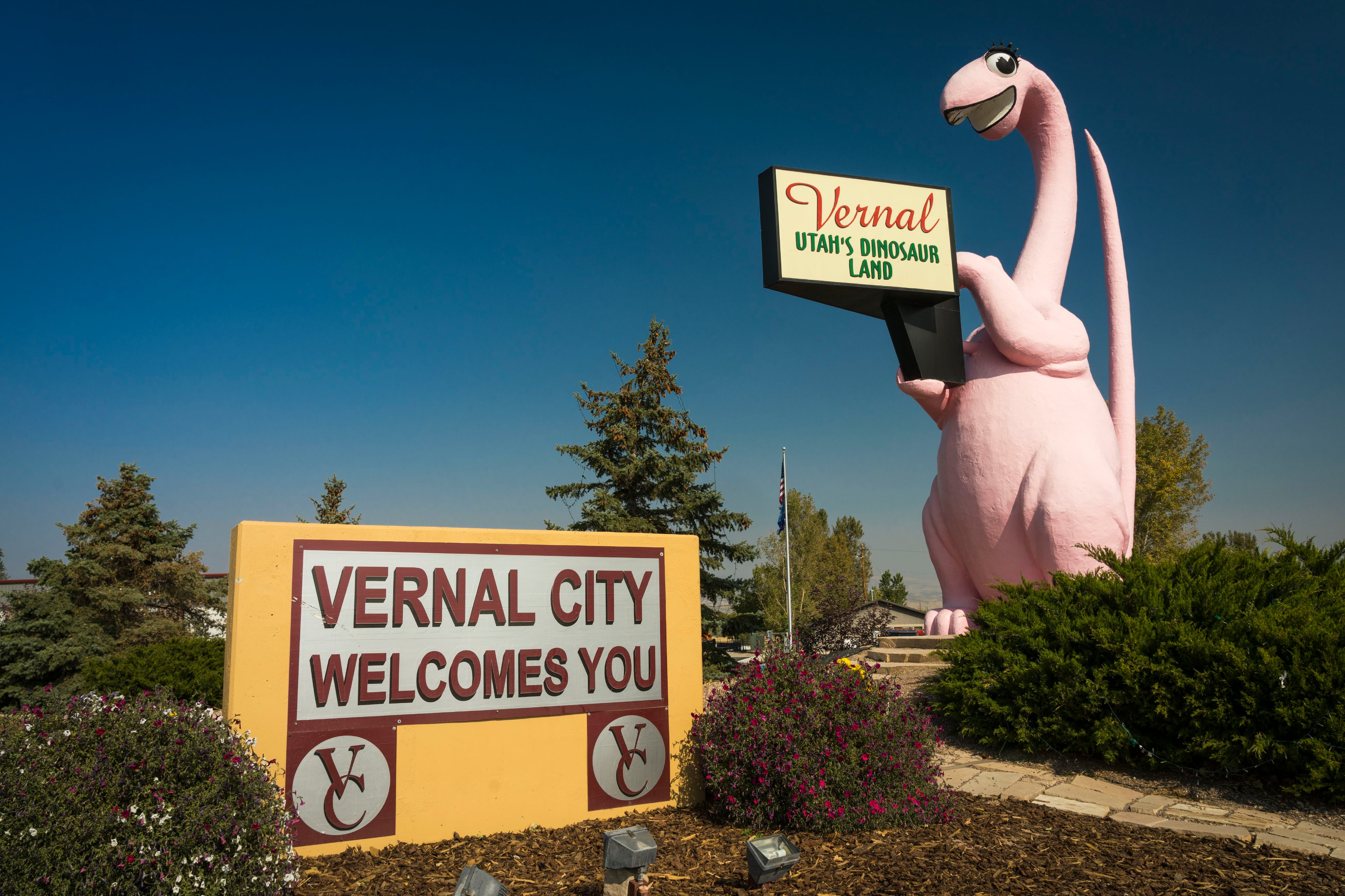 A dinosaur statue and welcome sign for Vernal, Utah.