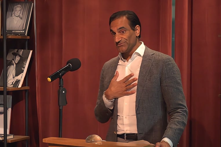 Jay Varma speaks from a podium.