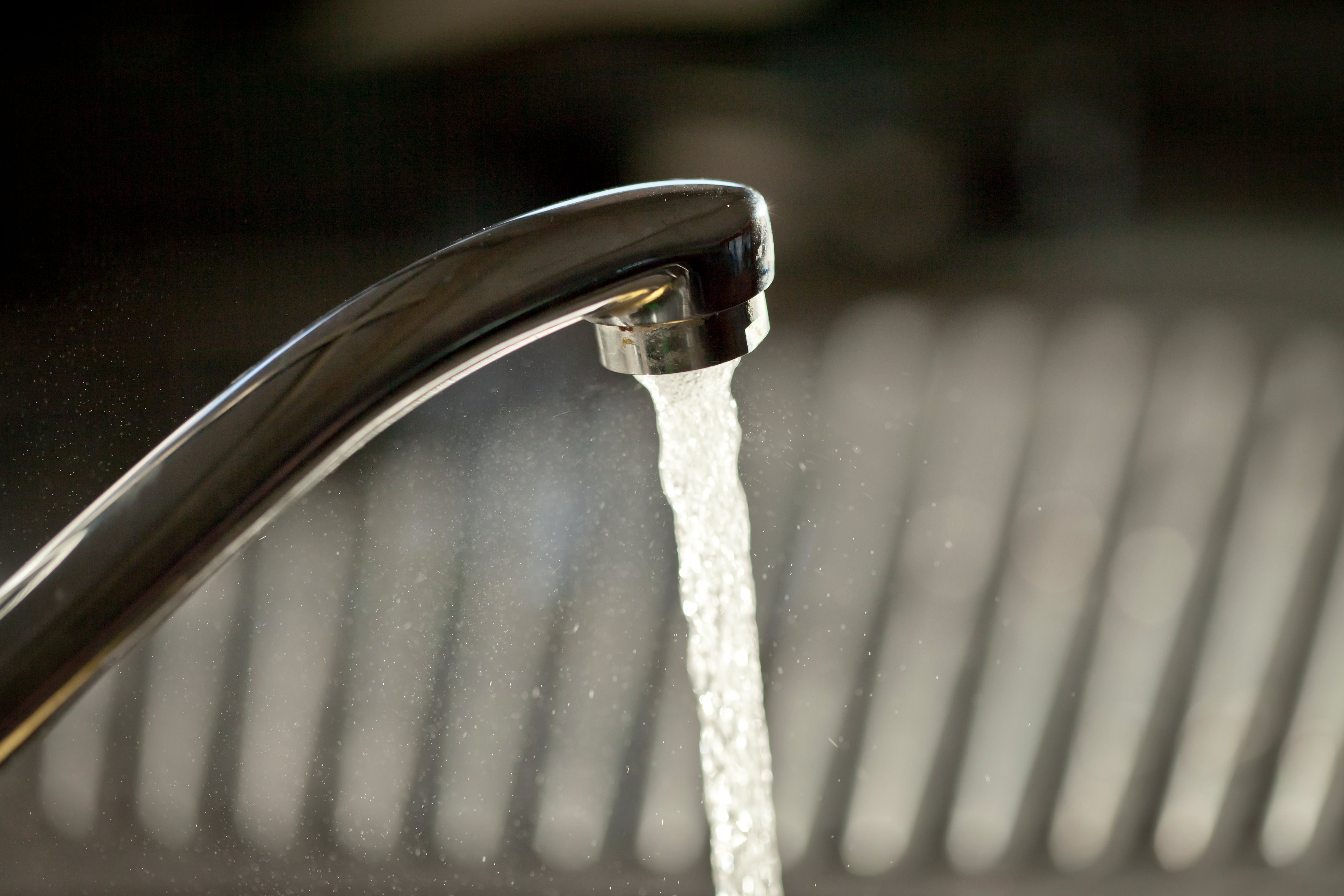 Water runs from a sink faucet.