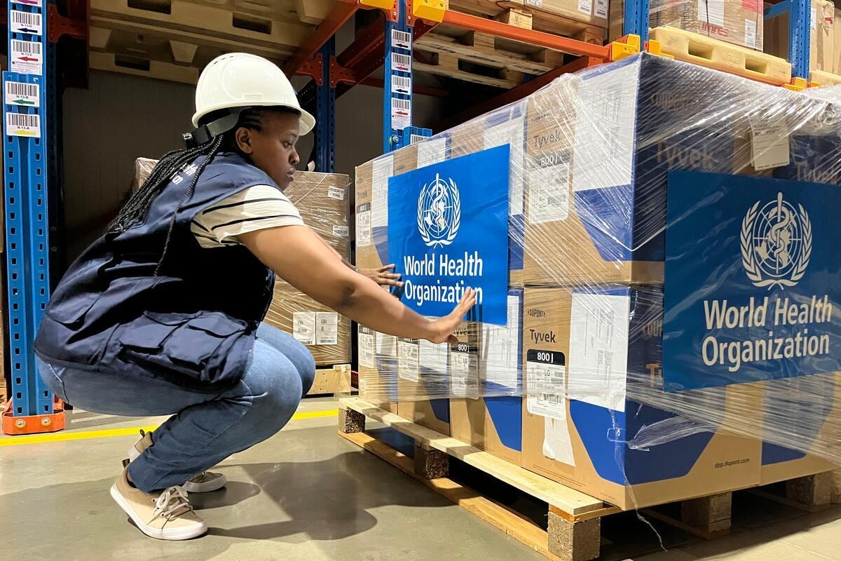 A woman checks a pallet of emergency supplies.