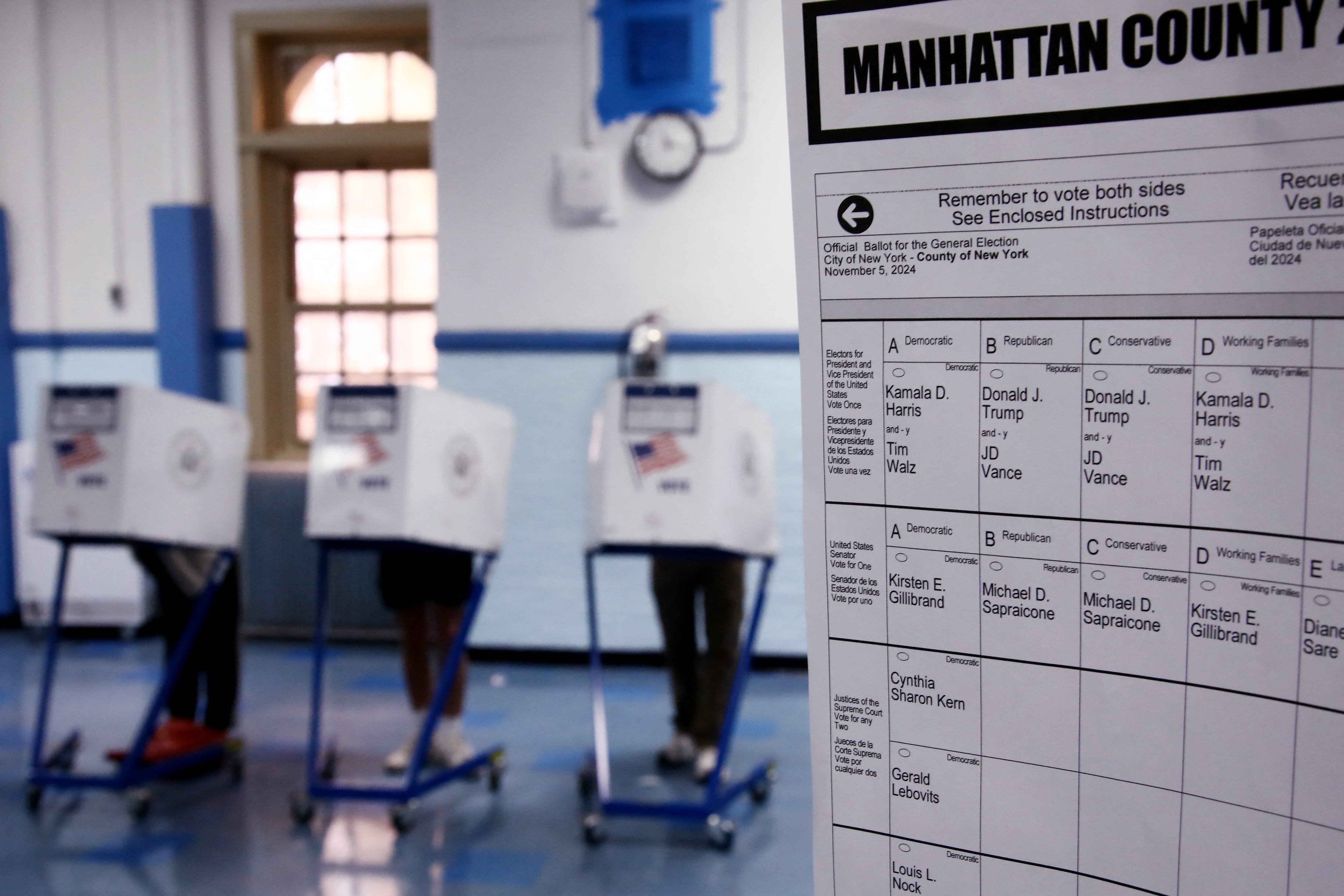 People stand in voting booths in Manhattan County, New York.