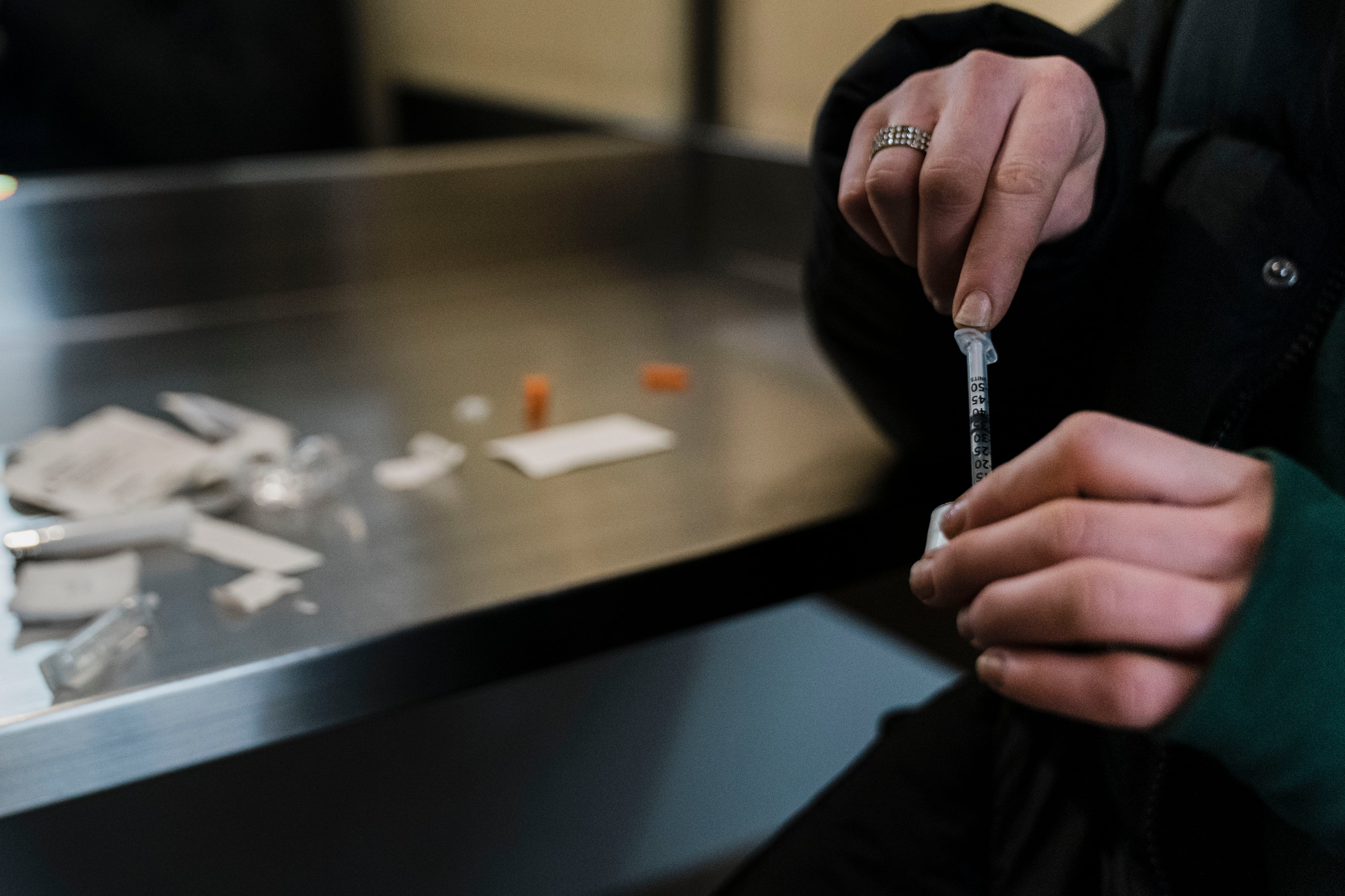 A woman holds a syringe at a safe injection site.