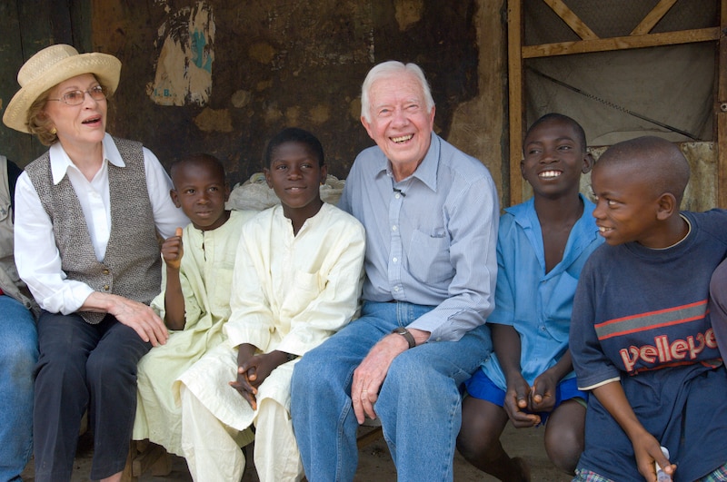 Rosalynn and Jimmy Carter pose in Nigeria with young boys who had schistosomiasis disease.