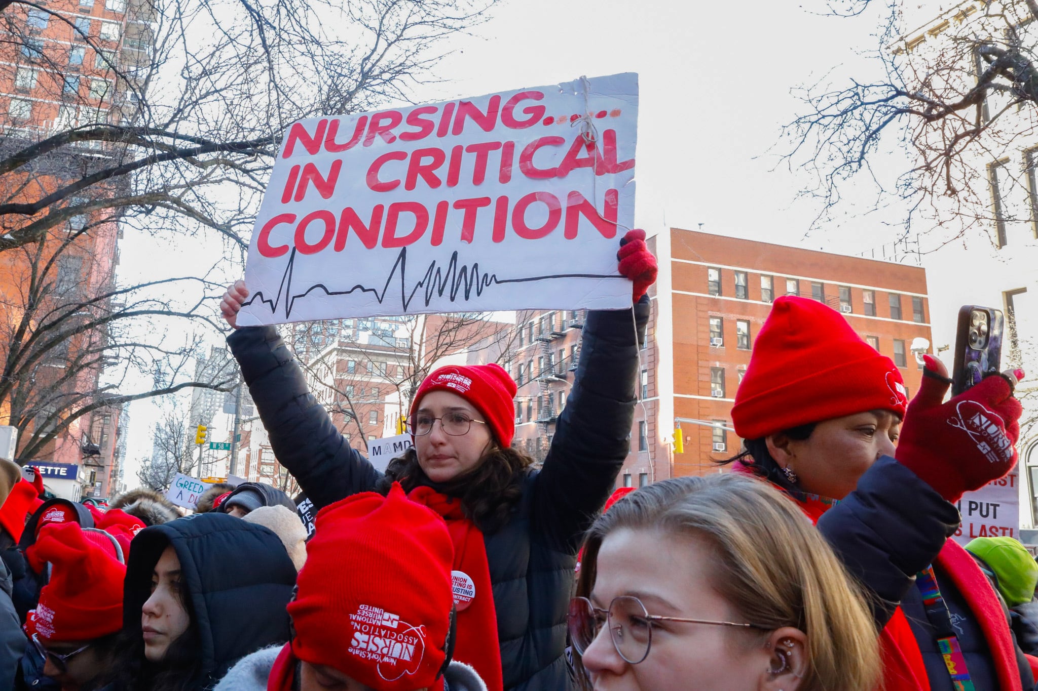 Mount Sinai West striking nurses watch Mayor Zohran Mamdani speak to the press.
