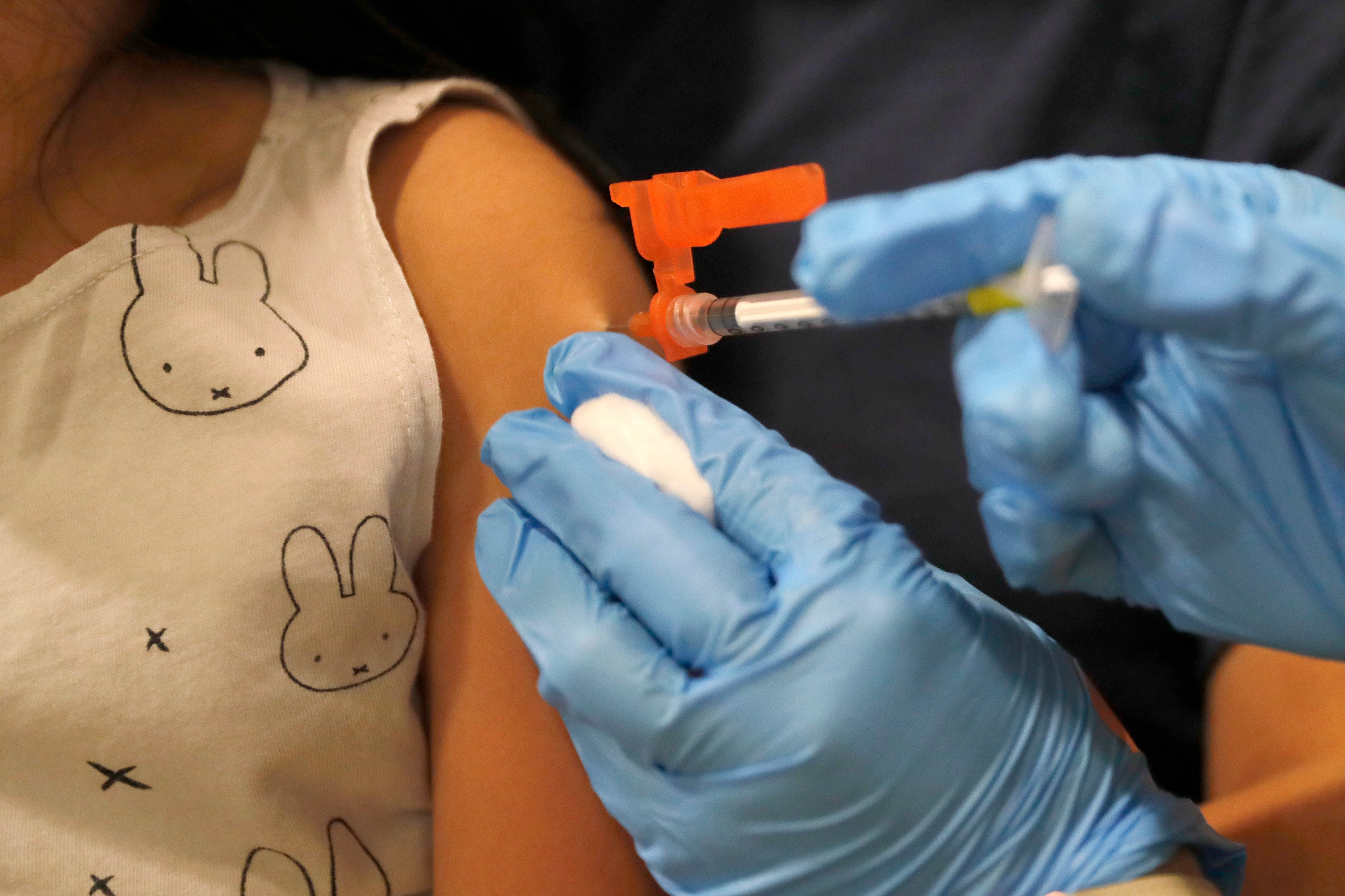 A child gets a vaccine shot in the arm.