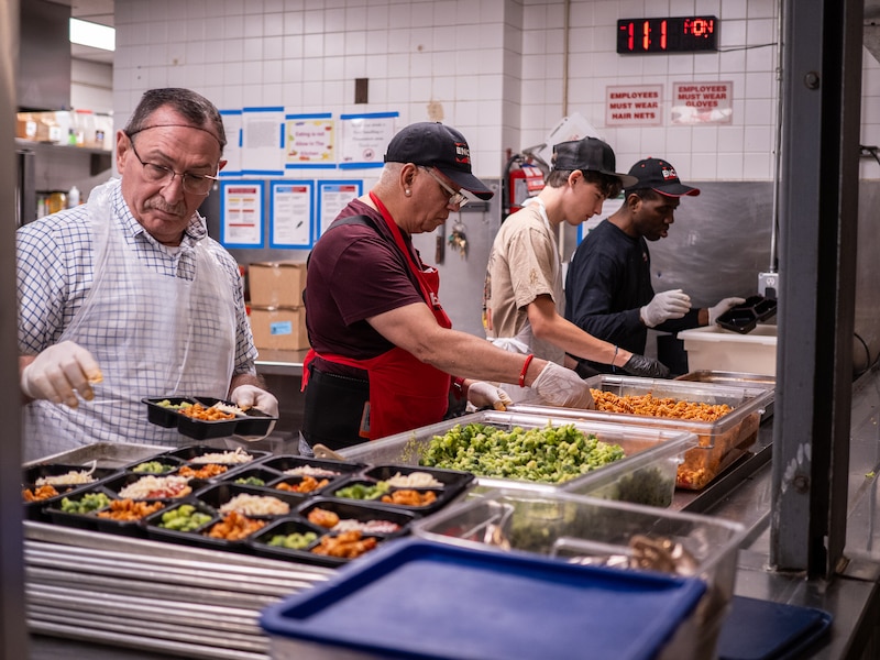 Four men work with food.