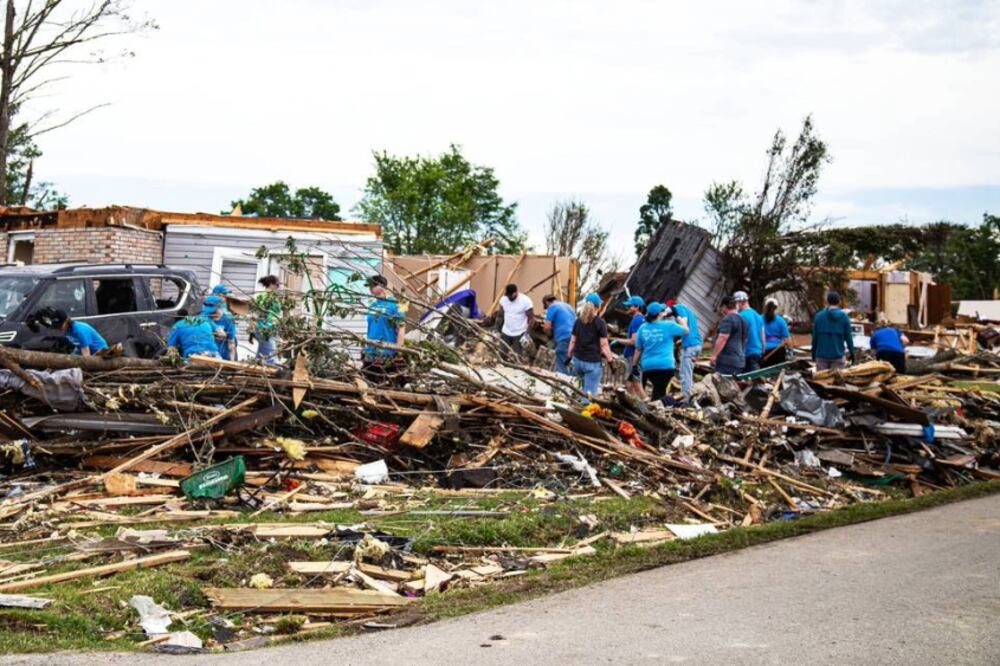 A crew of health care workers helps clean up debris after a tornado.