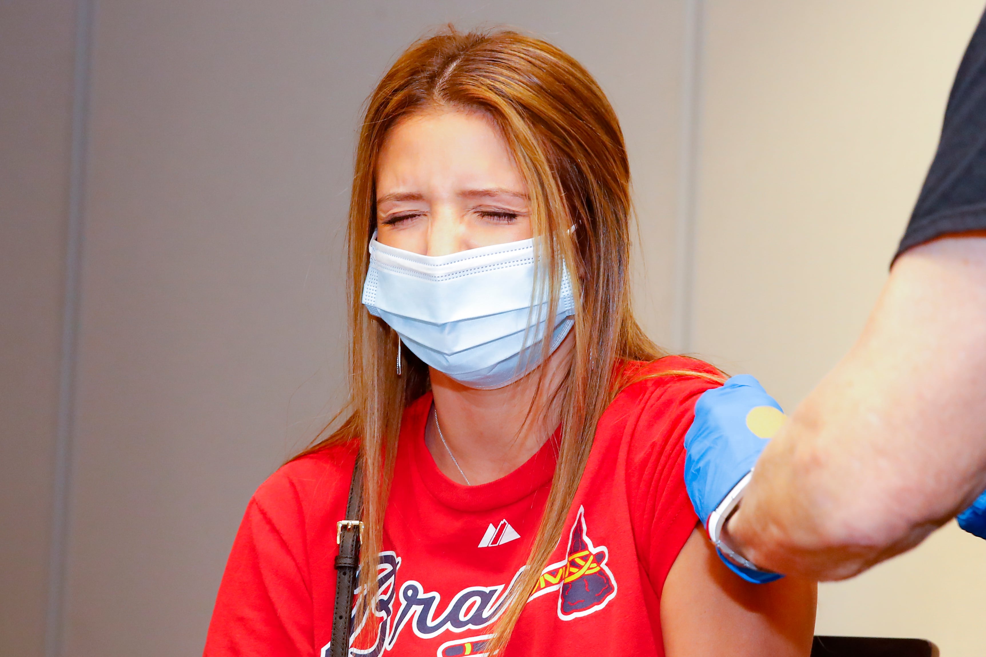 Woman wearing red Atlanta Braves T-shirt gets a Covid-19 vaccine shot.