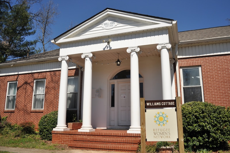 The front entrance to a large brick building with white columns.