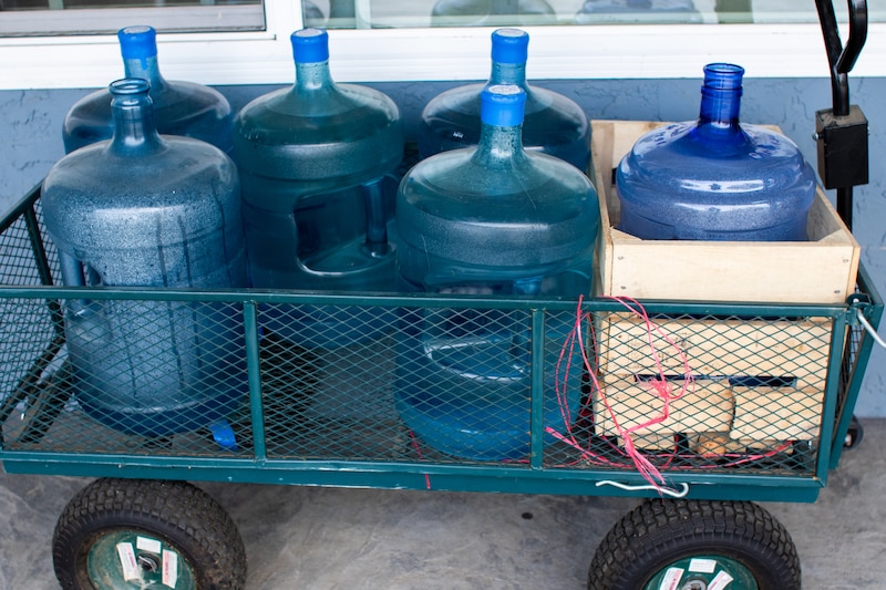 Six large water bottles are in a wagon.