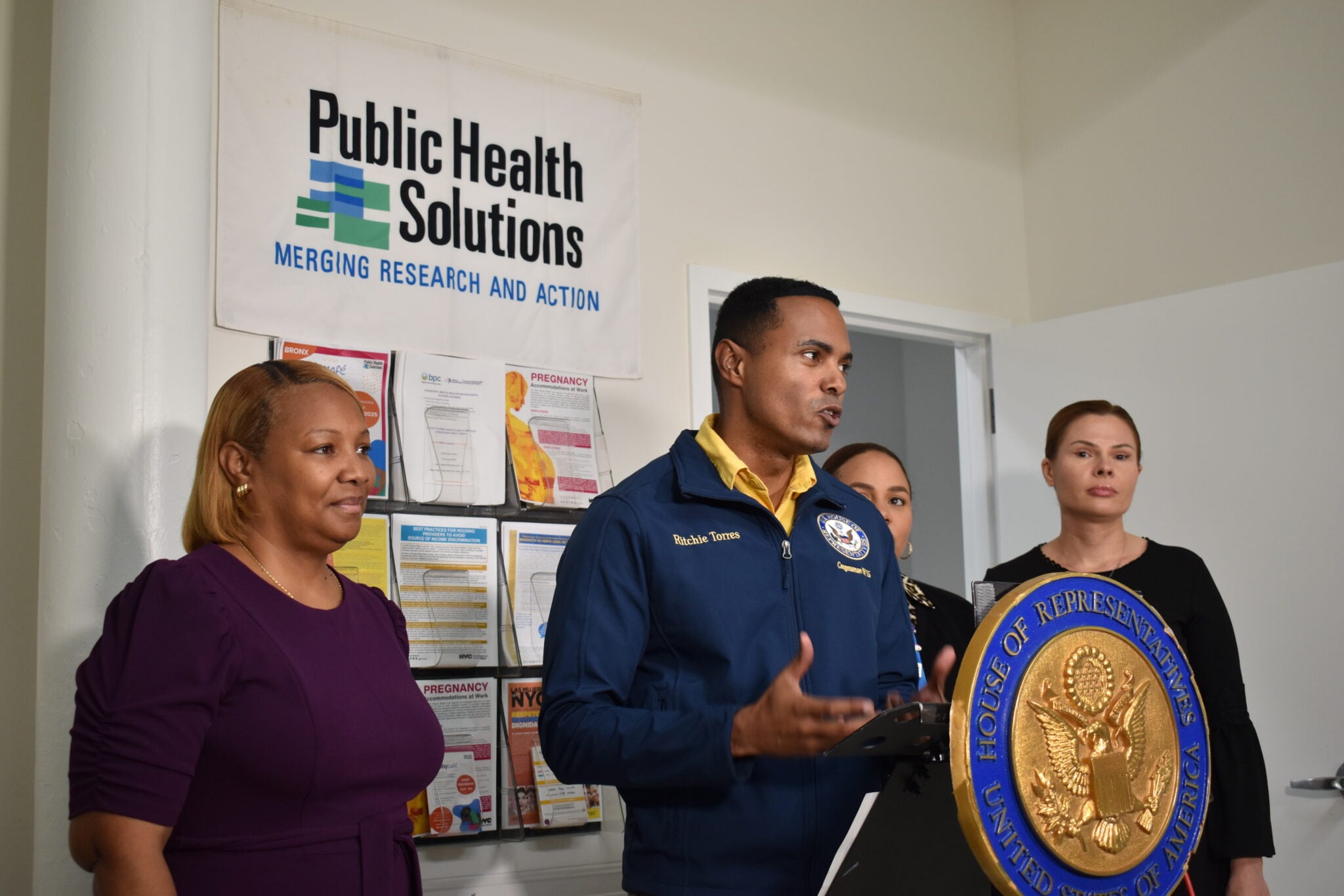 U.S. Rep. Ritchie Torres speaks at a podium, flanked by others.