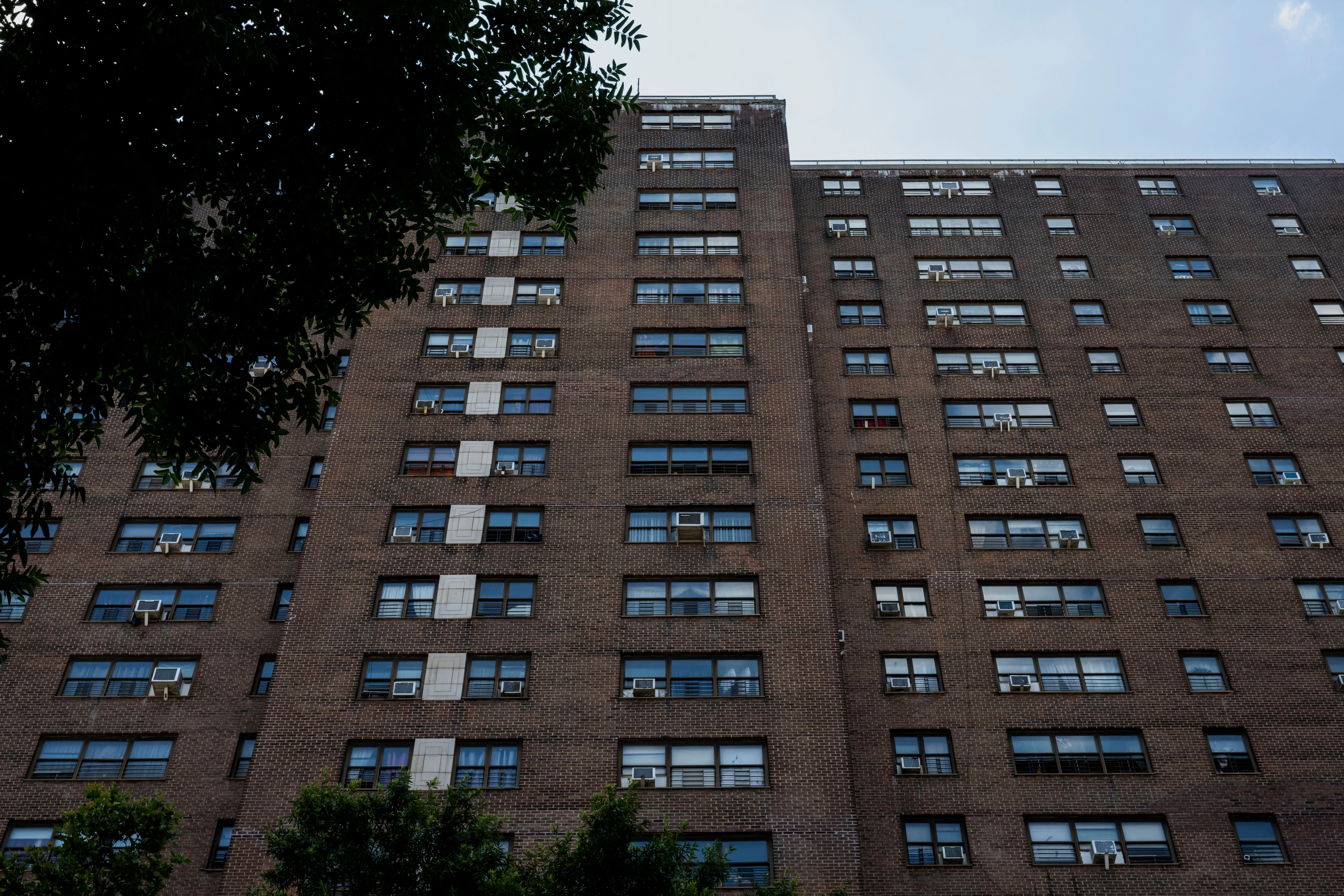 Air conditioning units hang on the windows of a housing project during a summer heat wave in the Bronx.