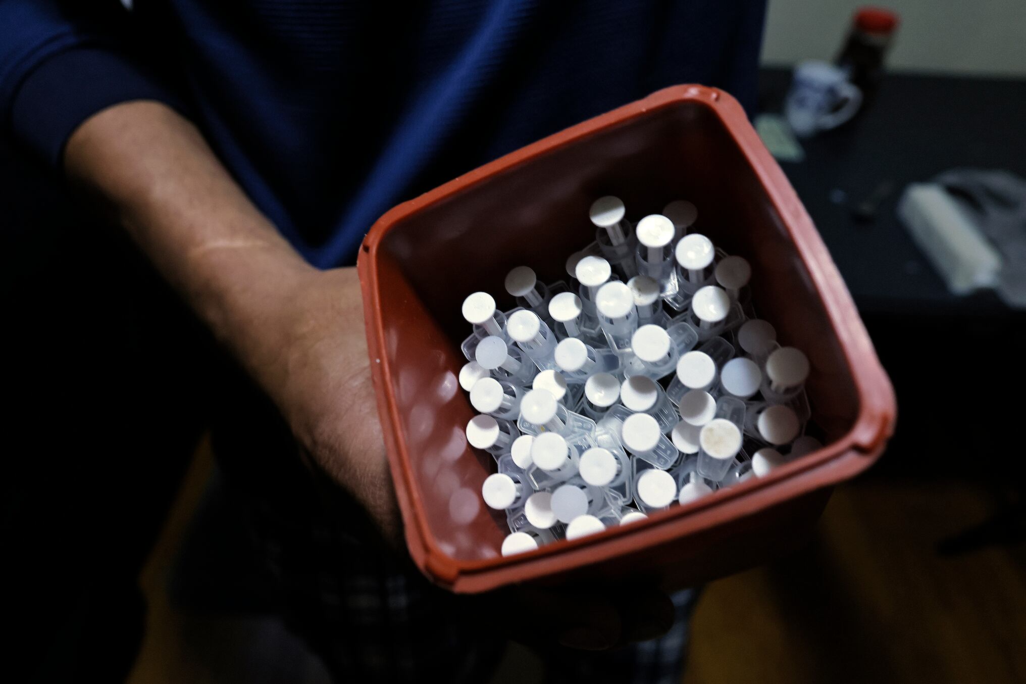 A container is filled with used syringes and needles for exchange.