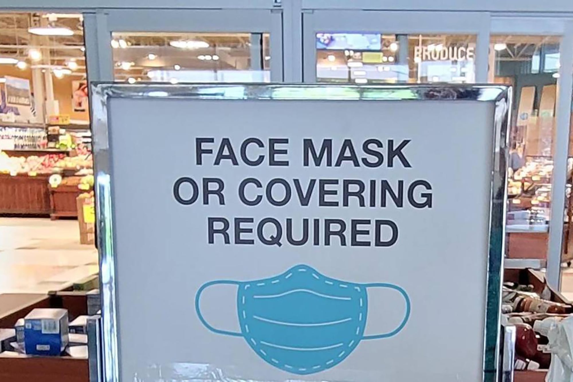 A sign at a store doorway says face masks are required.