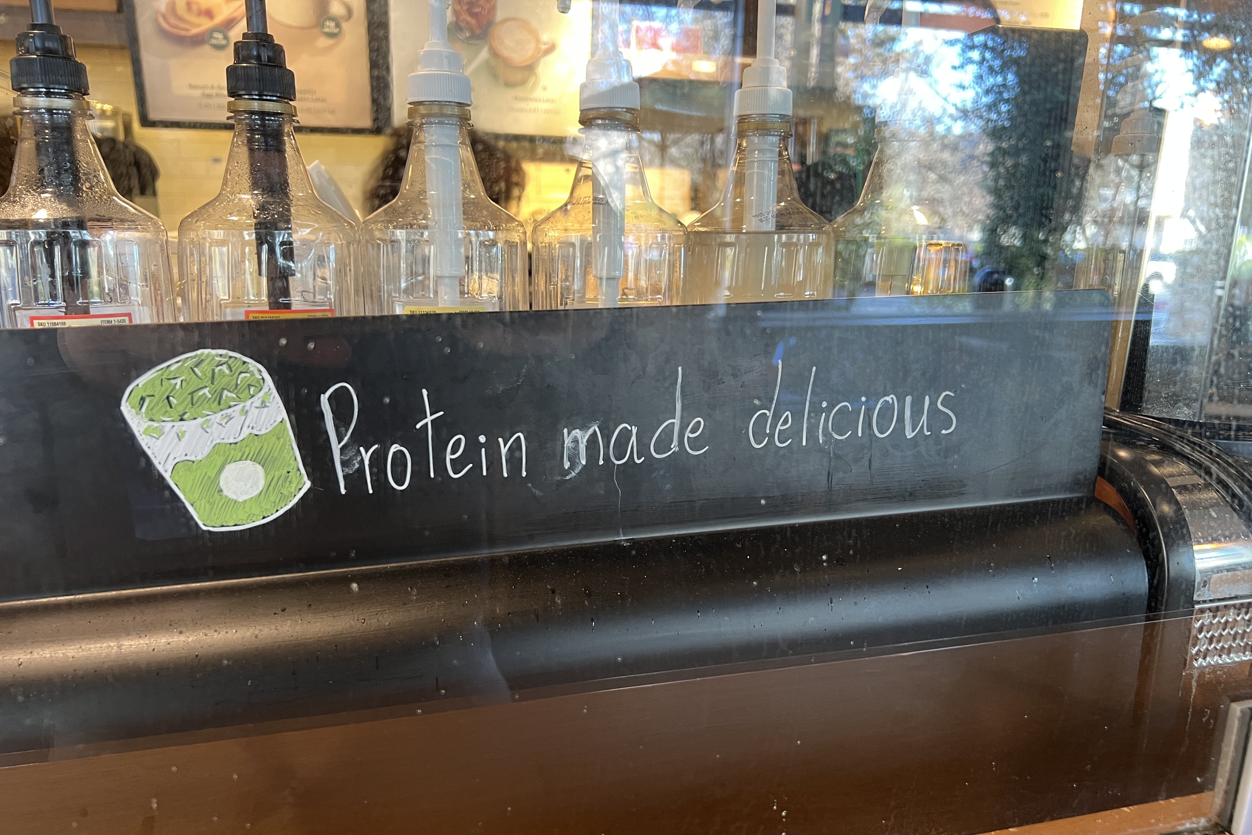 A sign in a coffee shop says "Protein made delicious."