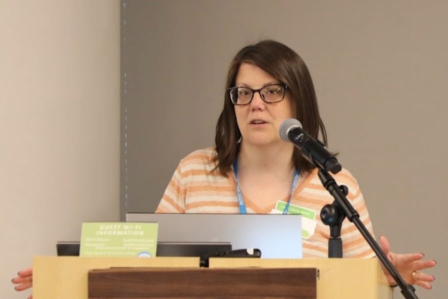 A woman speaks from a podium.
