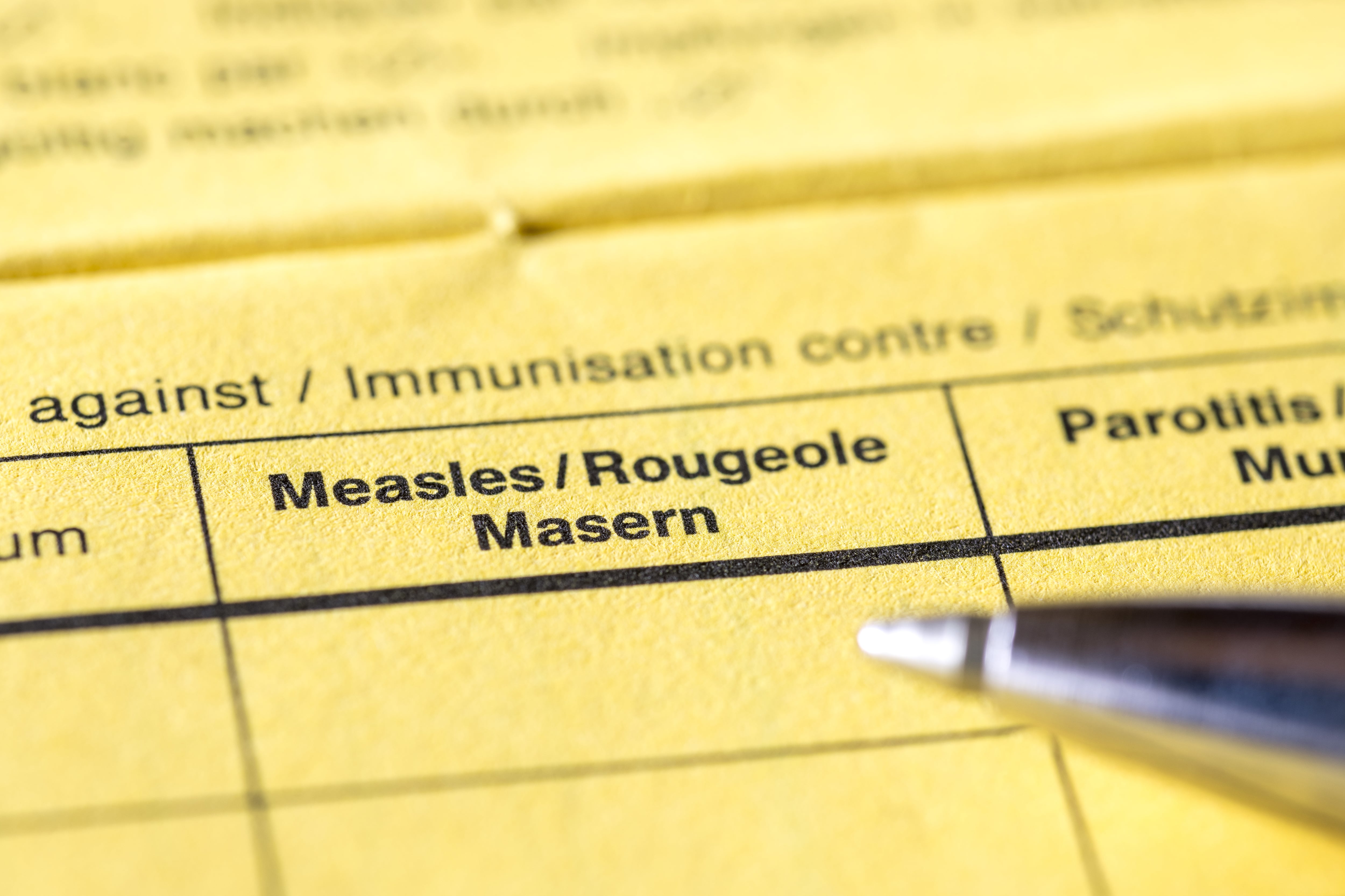 A paper form for filling in measles vaccine info.