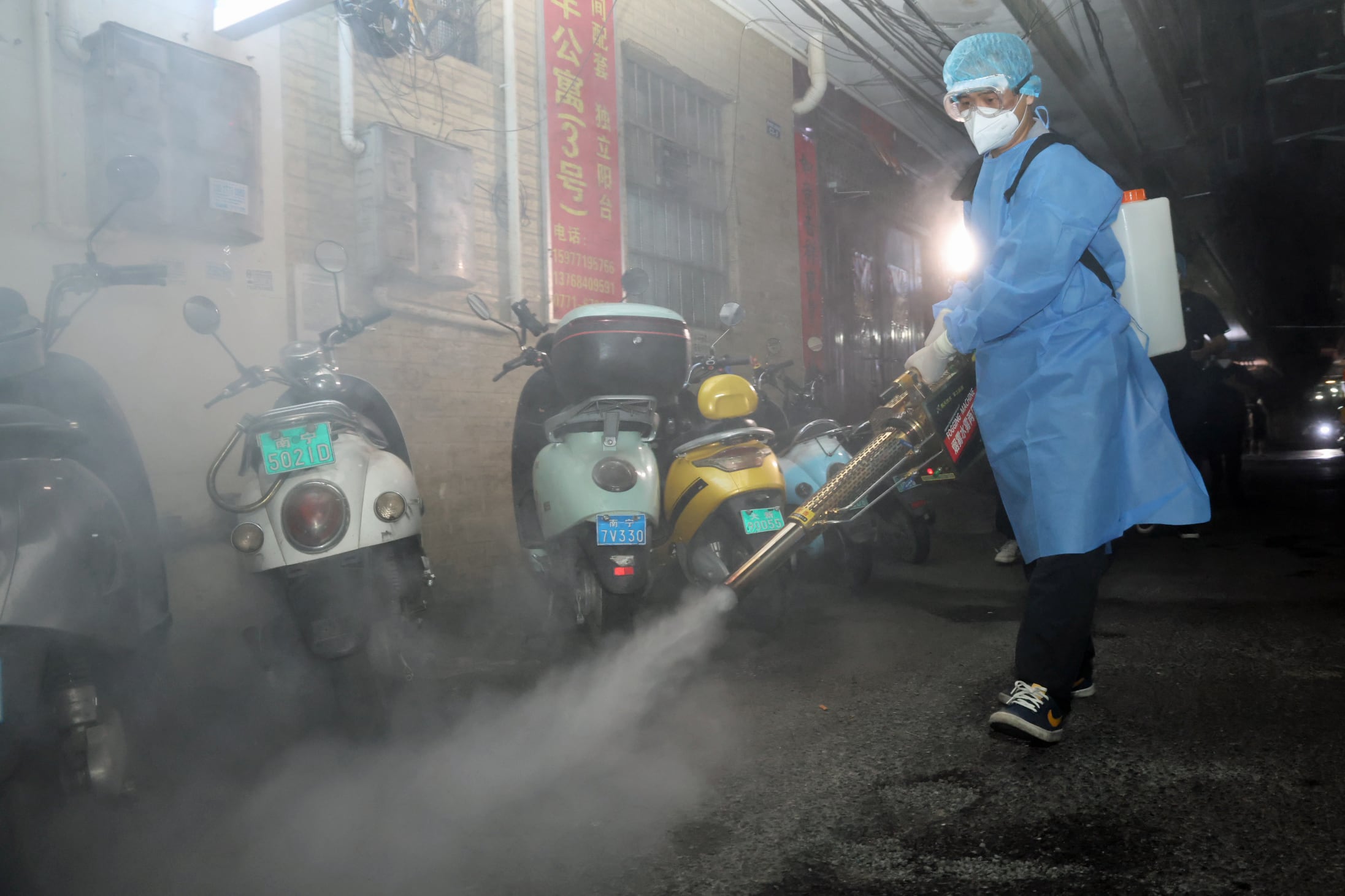 A person wearing protective gear sprays for mosquitoes in China.