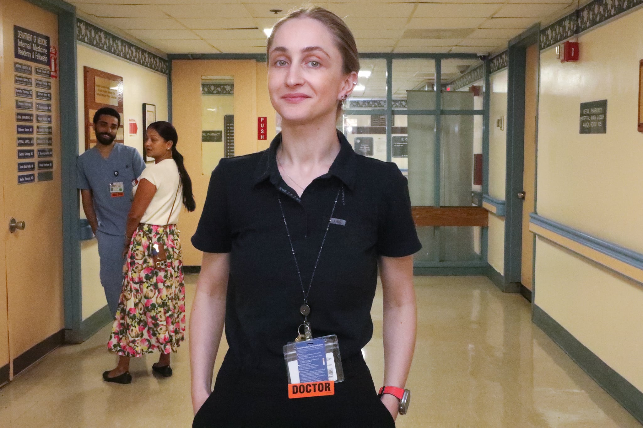 A doctor stands in a hospital hallway.