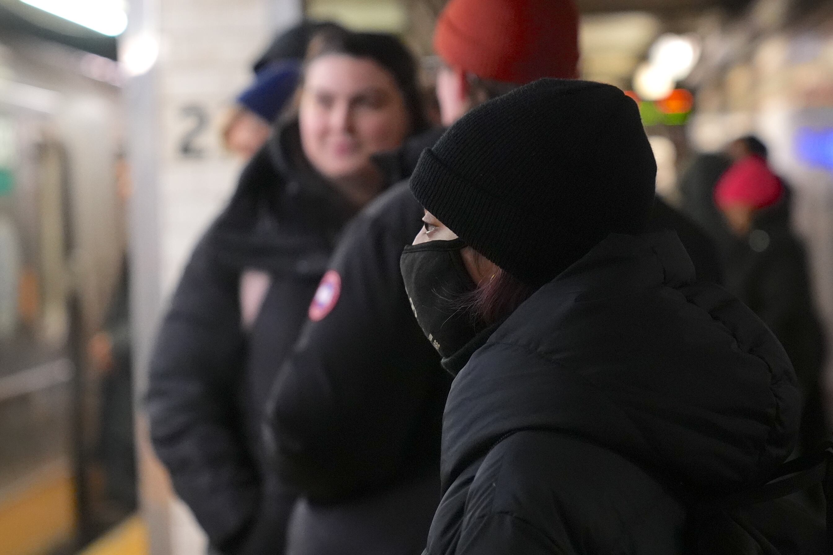 A person wears a mask on a subway platform.