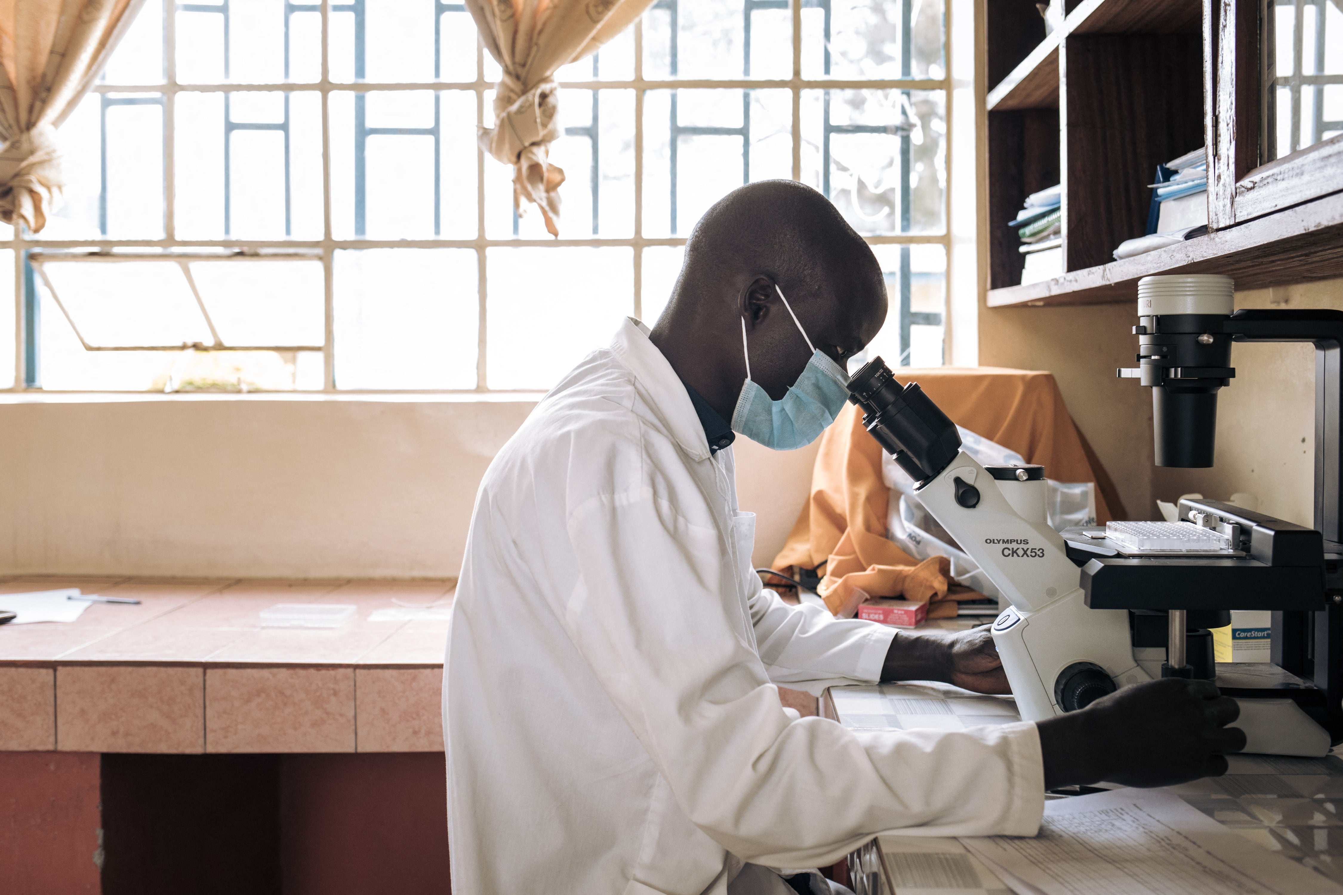 A researcher looks through a microscope.