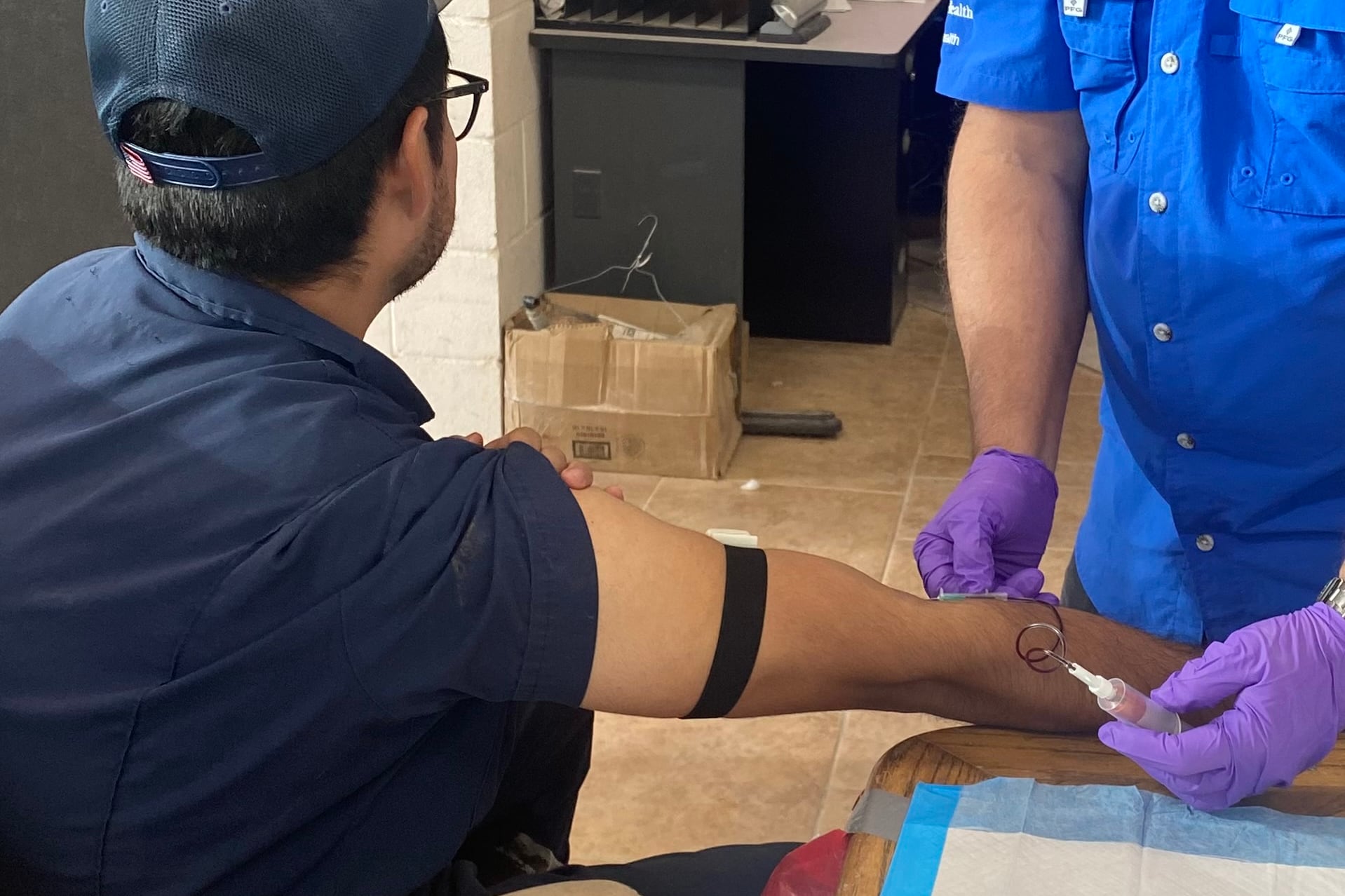 A researcher draws blood from a farmworker.