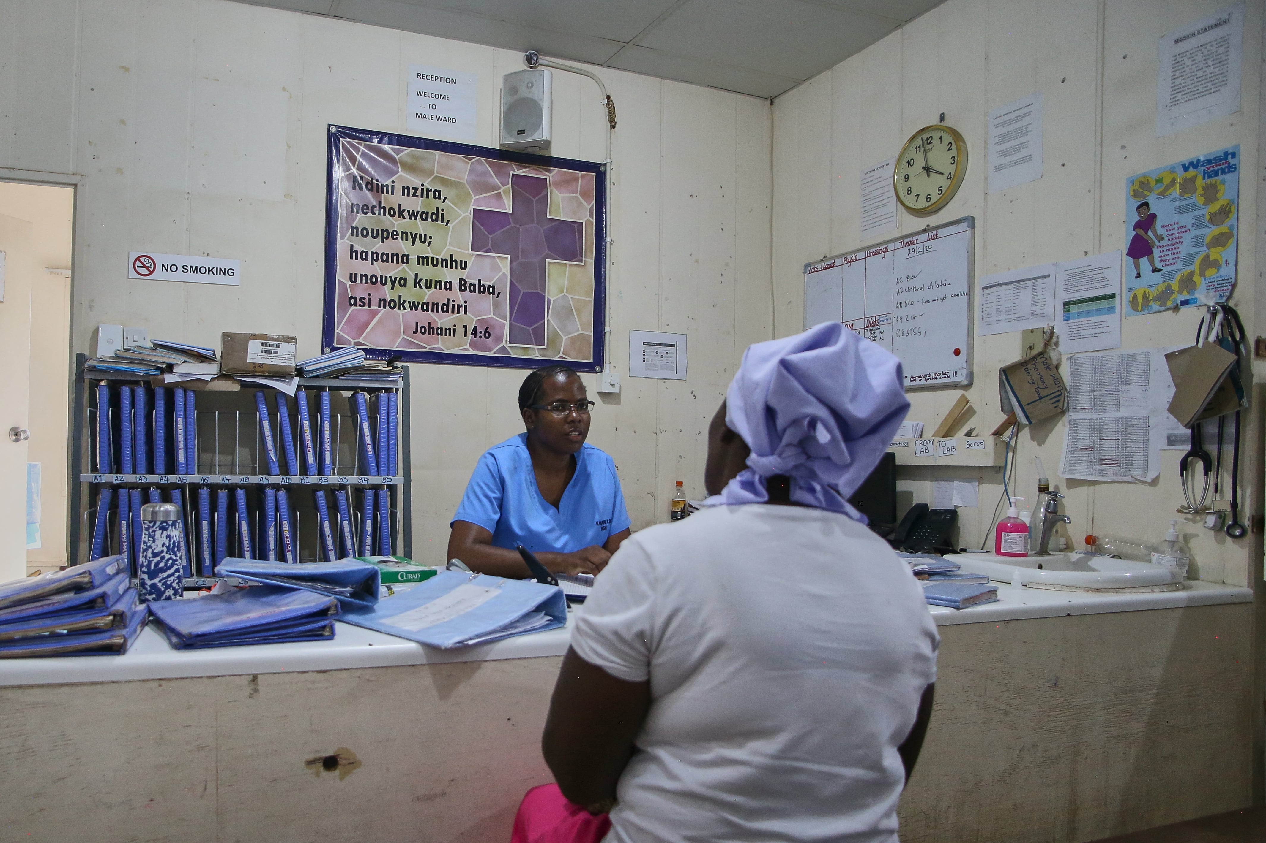 A patient speaks to a health care worker in a medical office.