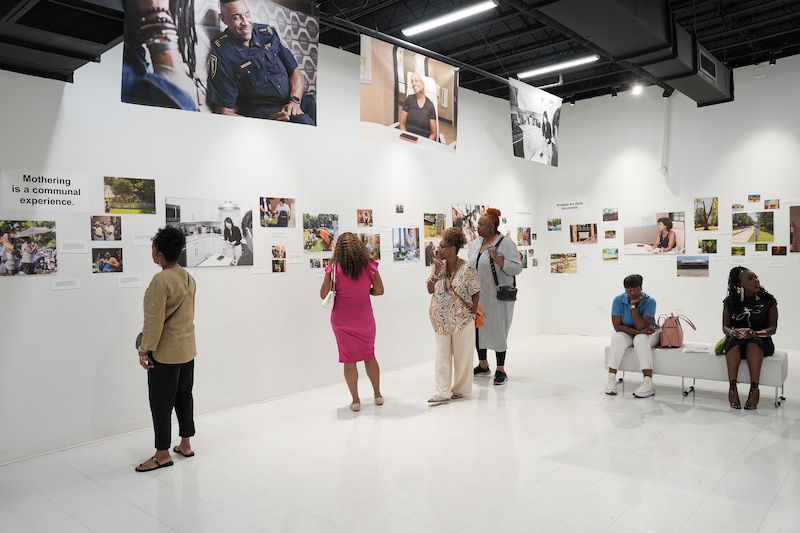 People look at photos and read comments in an exhibit.