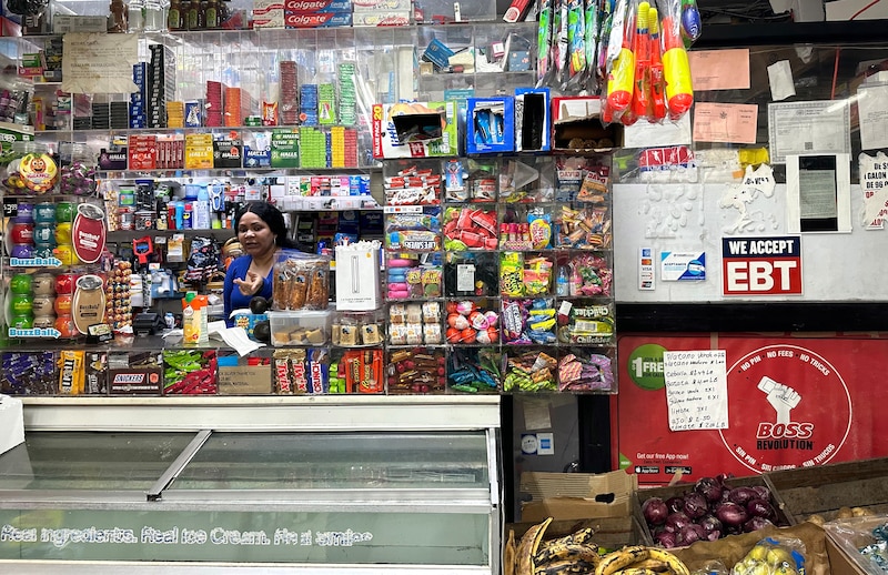 A woman stands among all the items at a store.