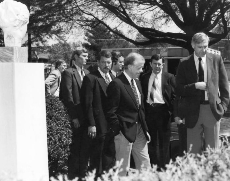President Jimmy Carter walks with a group of men, including Dr. William H. Foege, outside at the CDC headquarters in Atlanta.