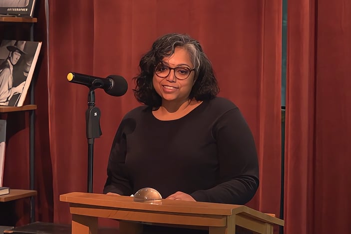 Vidya Thirumoorthi speaks from a podium.