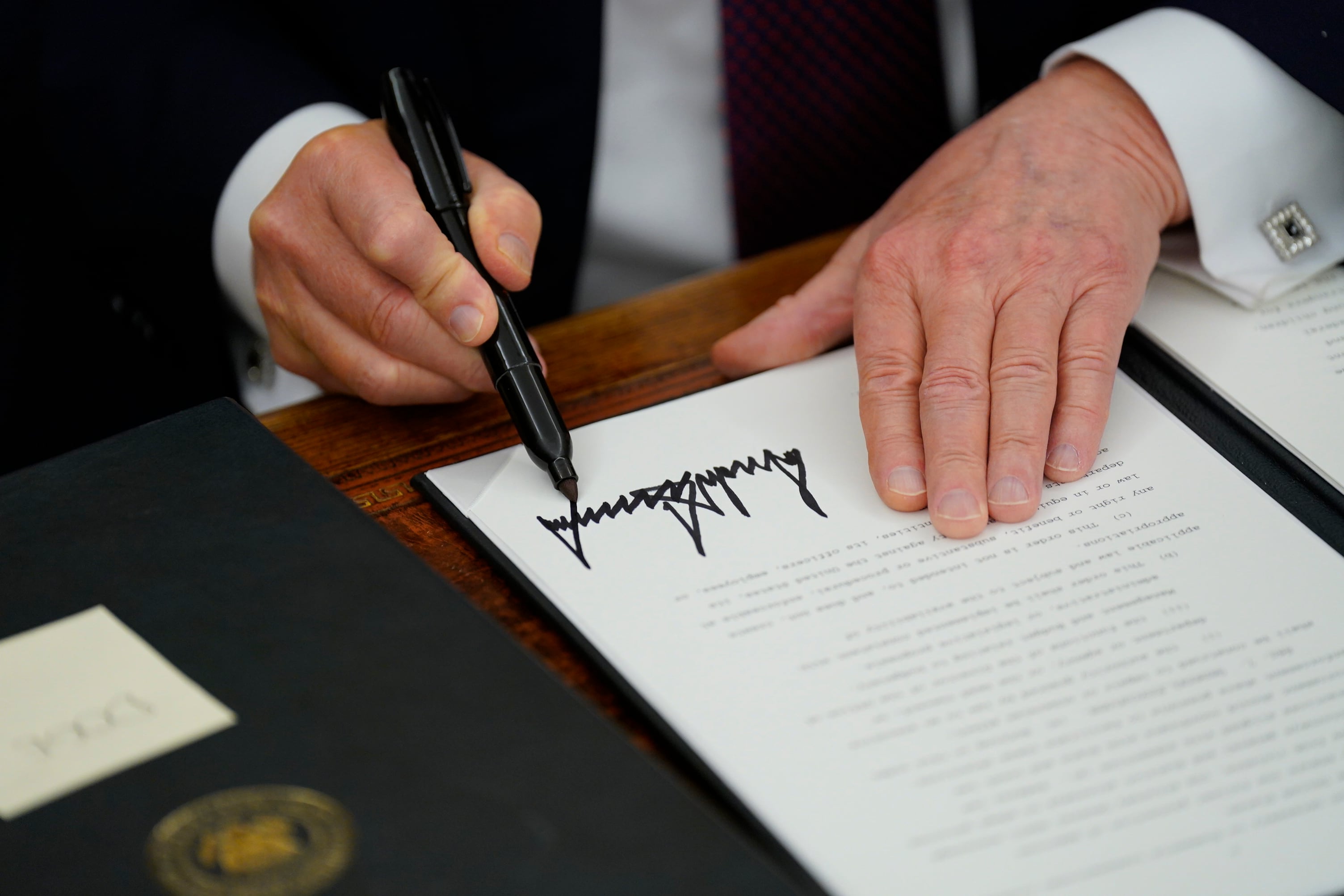 President Donald Trump signs an executive order.