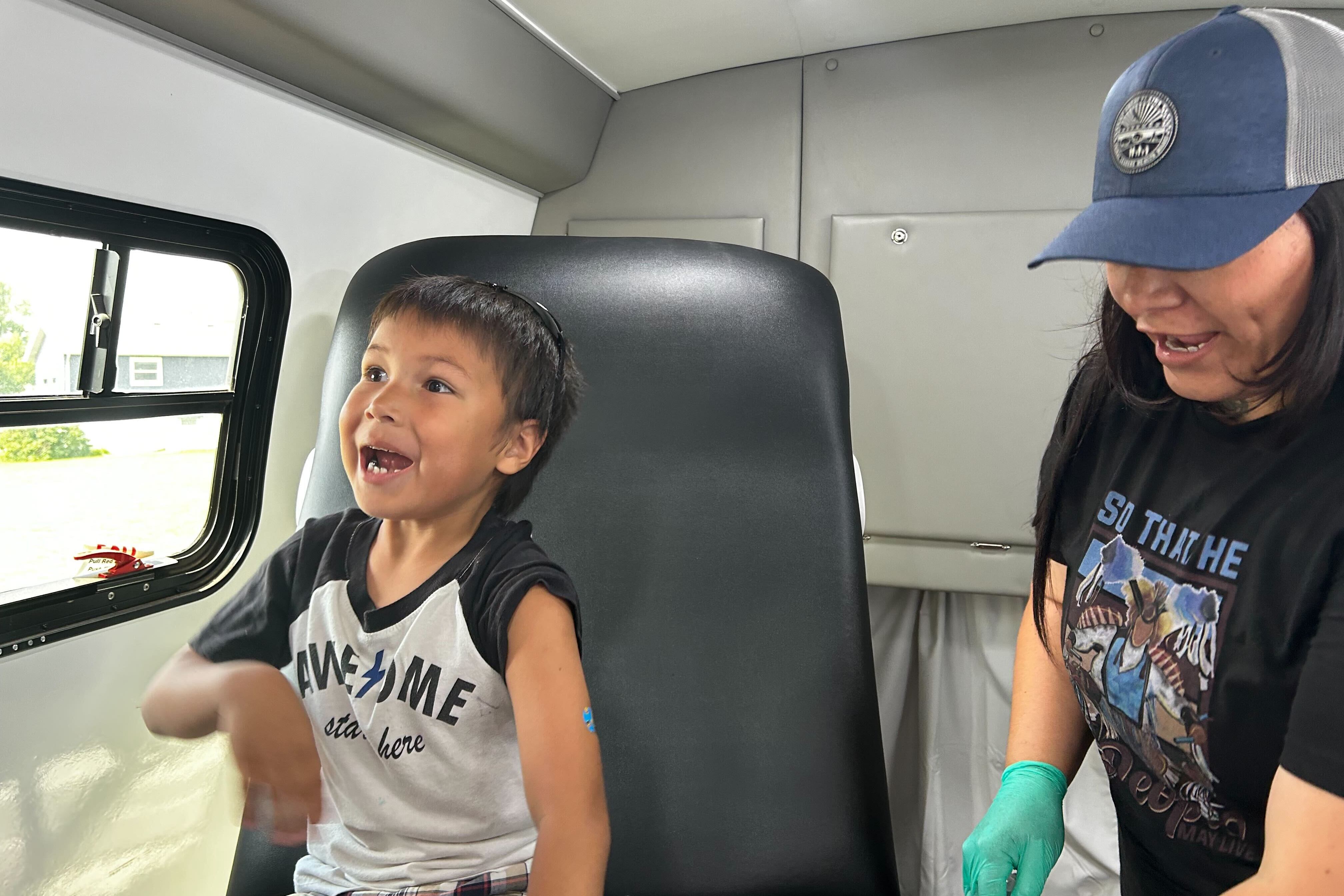 A boy smiles after getting a measles shot in a mobile clinic.