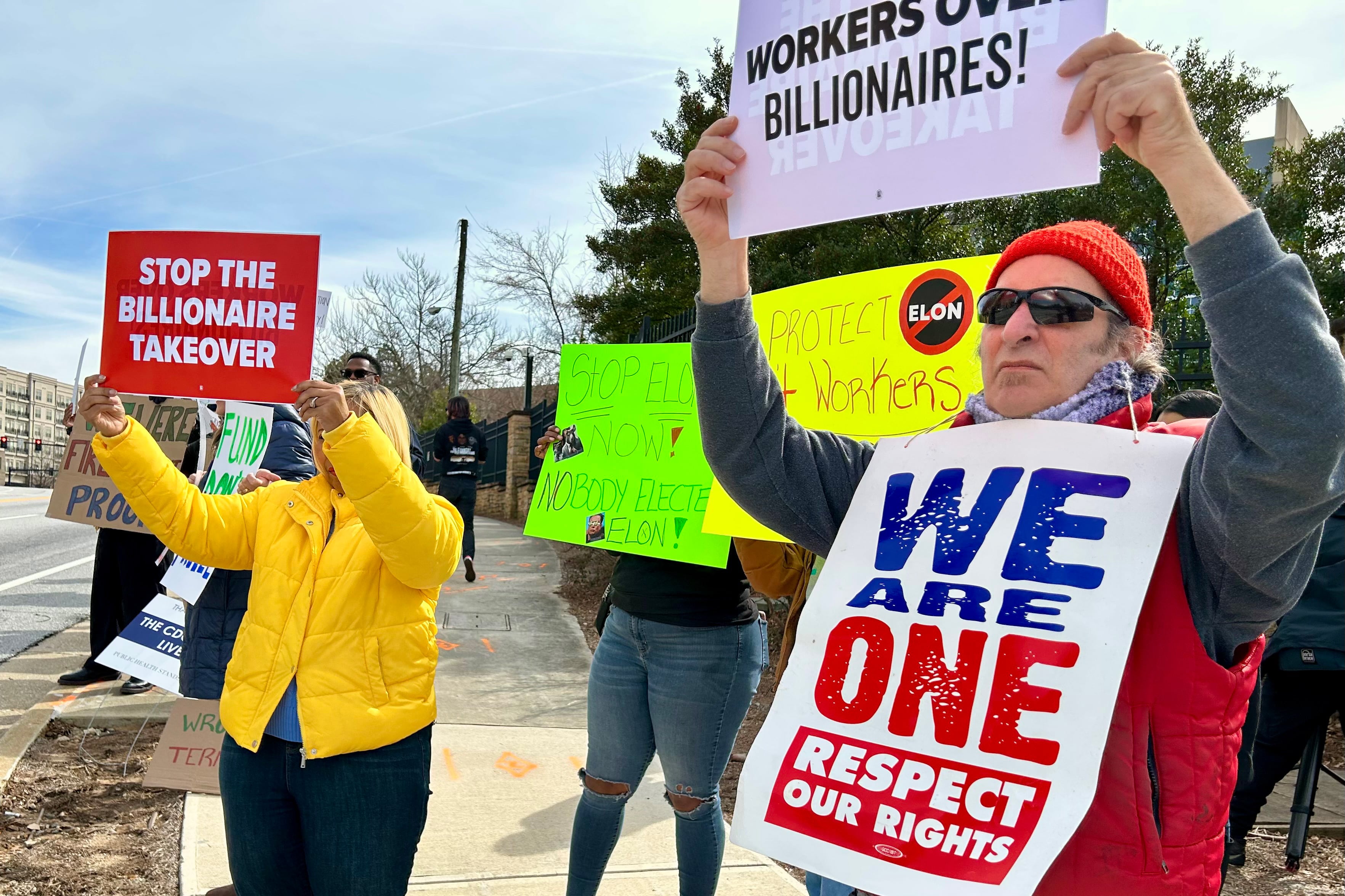 CDC workers hold signs in protest against mass firings.
